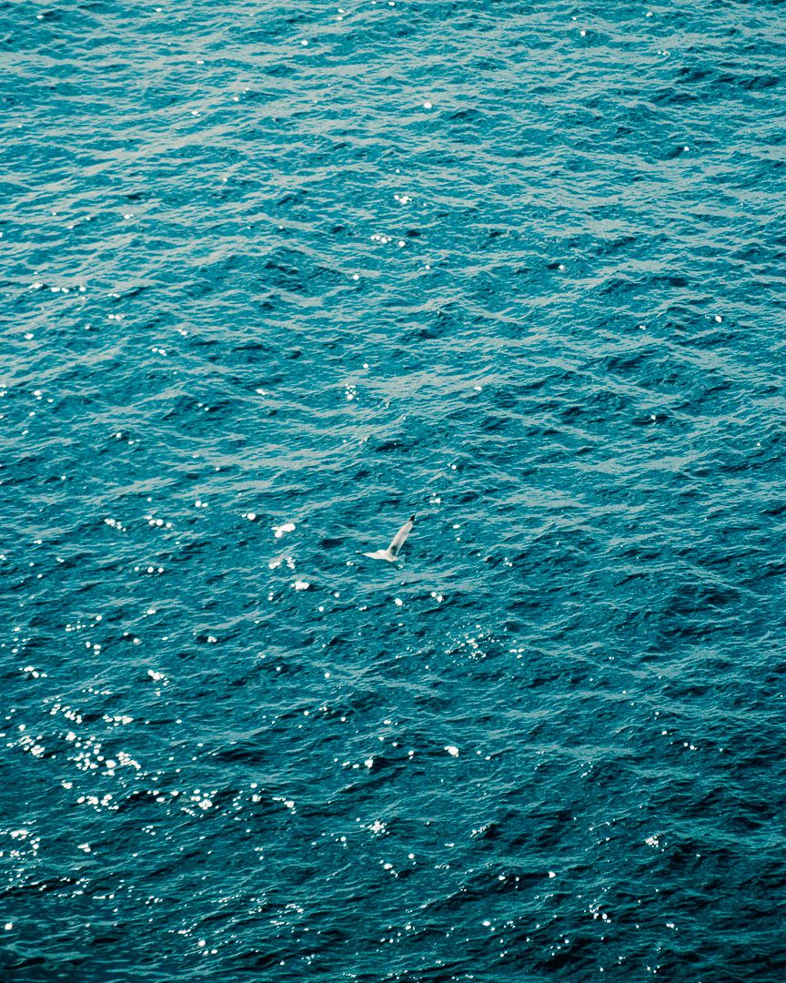 Aerial view of textured turquoise sea with gentle waves.