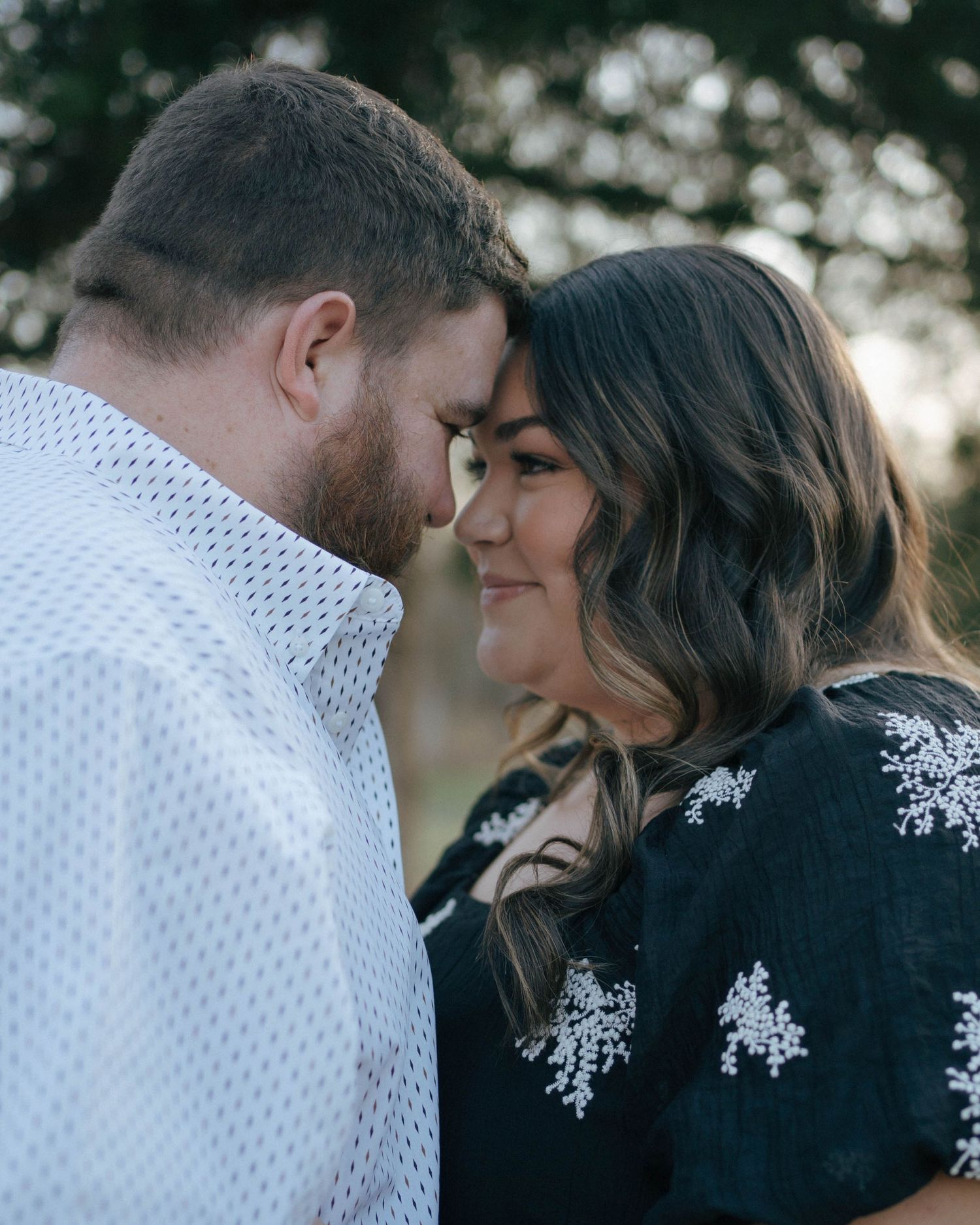 A tender moment shared between two people in a romantic outdoor setting with soft bokeh lighting.