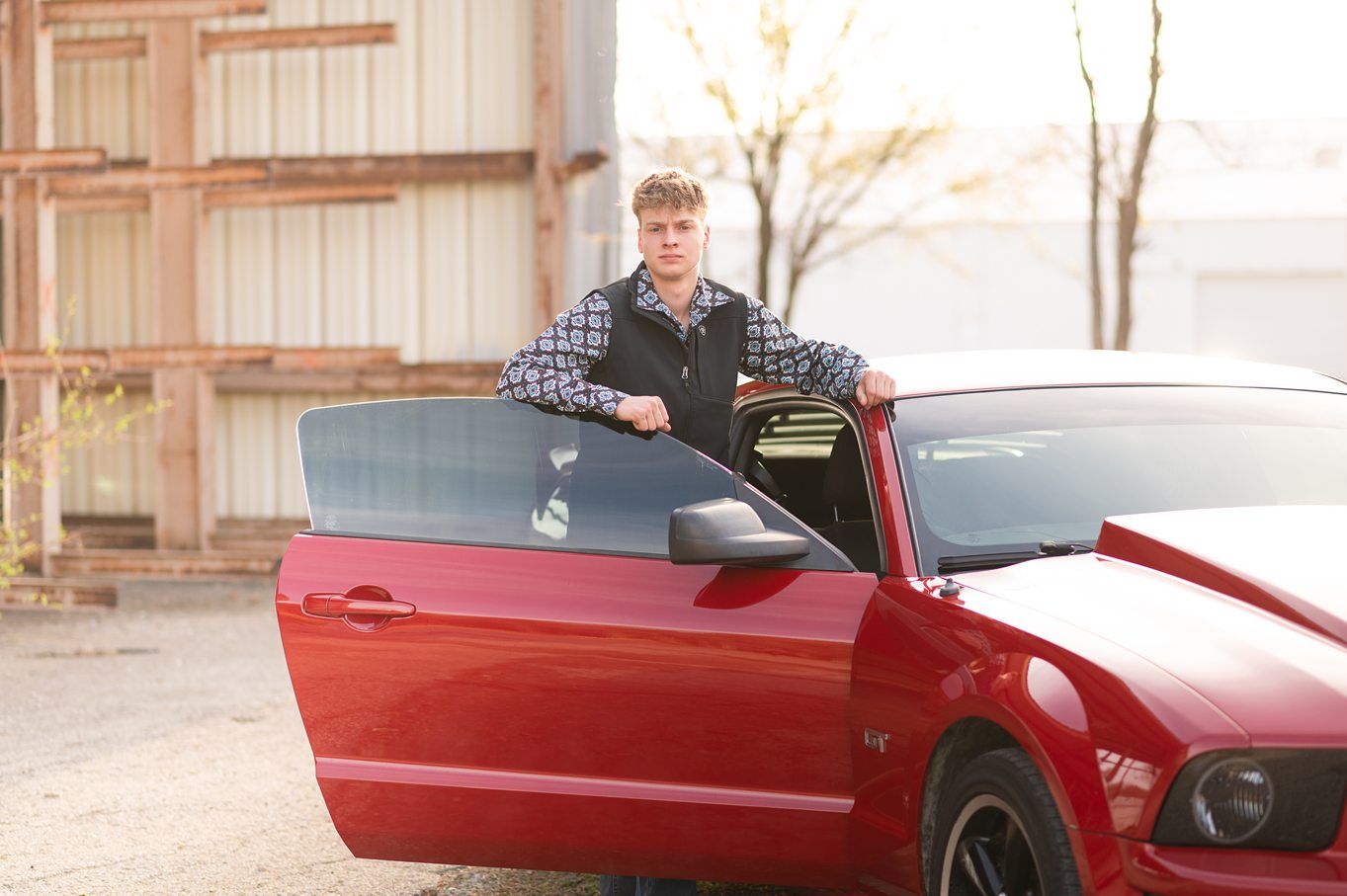 Senior Guy with Red Sports Car in Downtown Bartlesville and Field by Bartlesville Photographer Kristi Bray