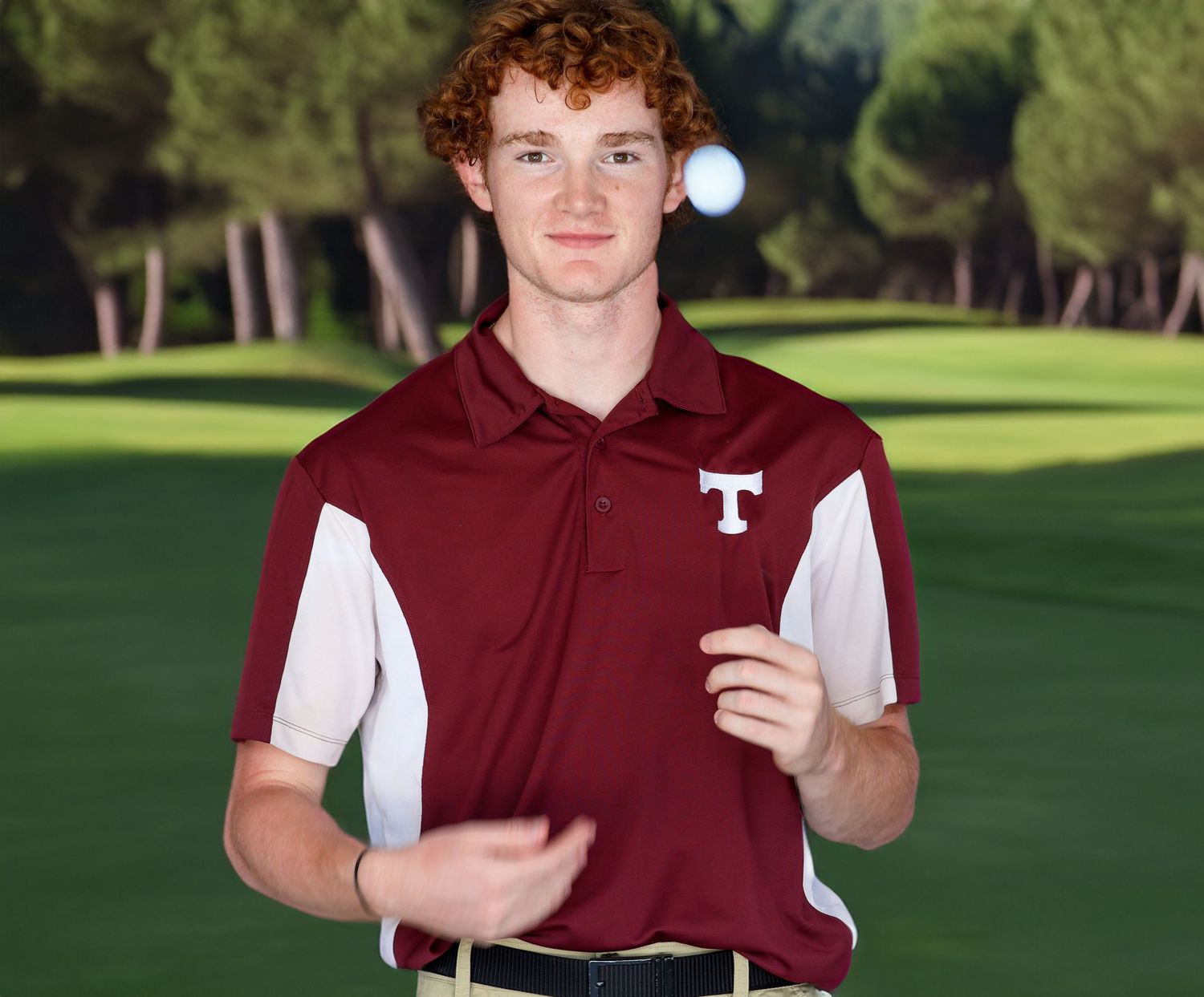 Tarpon High school golfer wearing maroon and white polo with T logo stands on golf course holding golf ball.