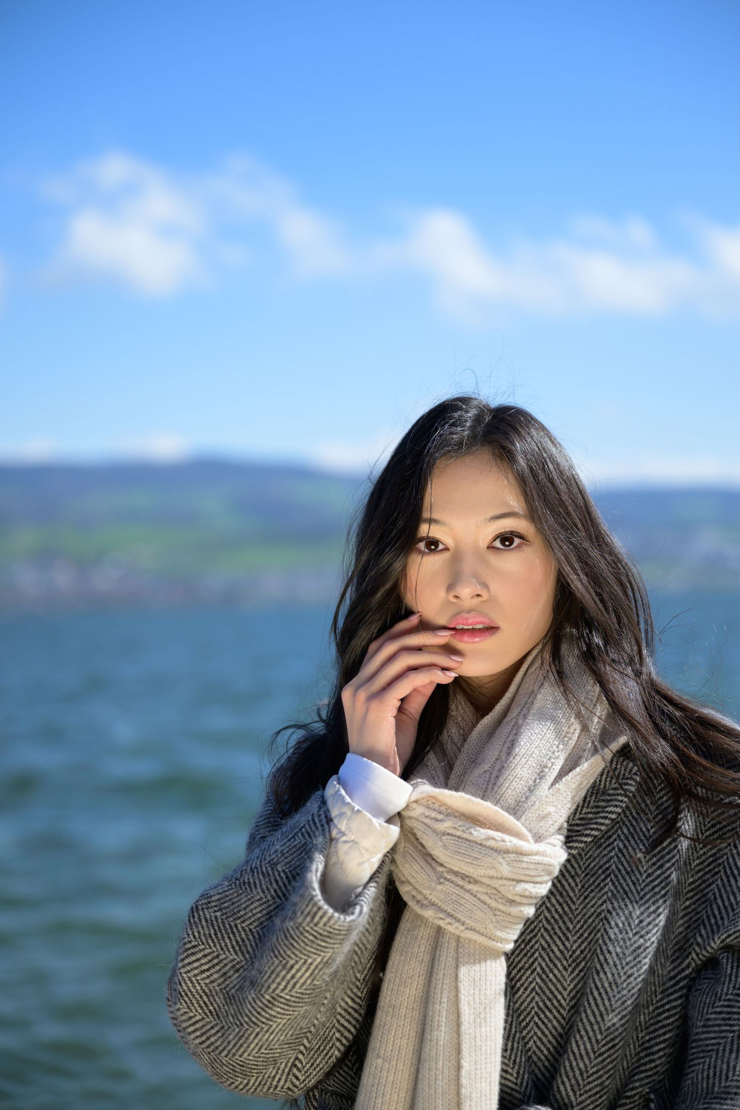 Natural beauty portrait of model in Zurich wearing a cream scarf. Close-up outdoor skincare photo with glowing skin and minimal makeup.Mode
