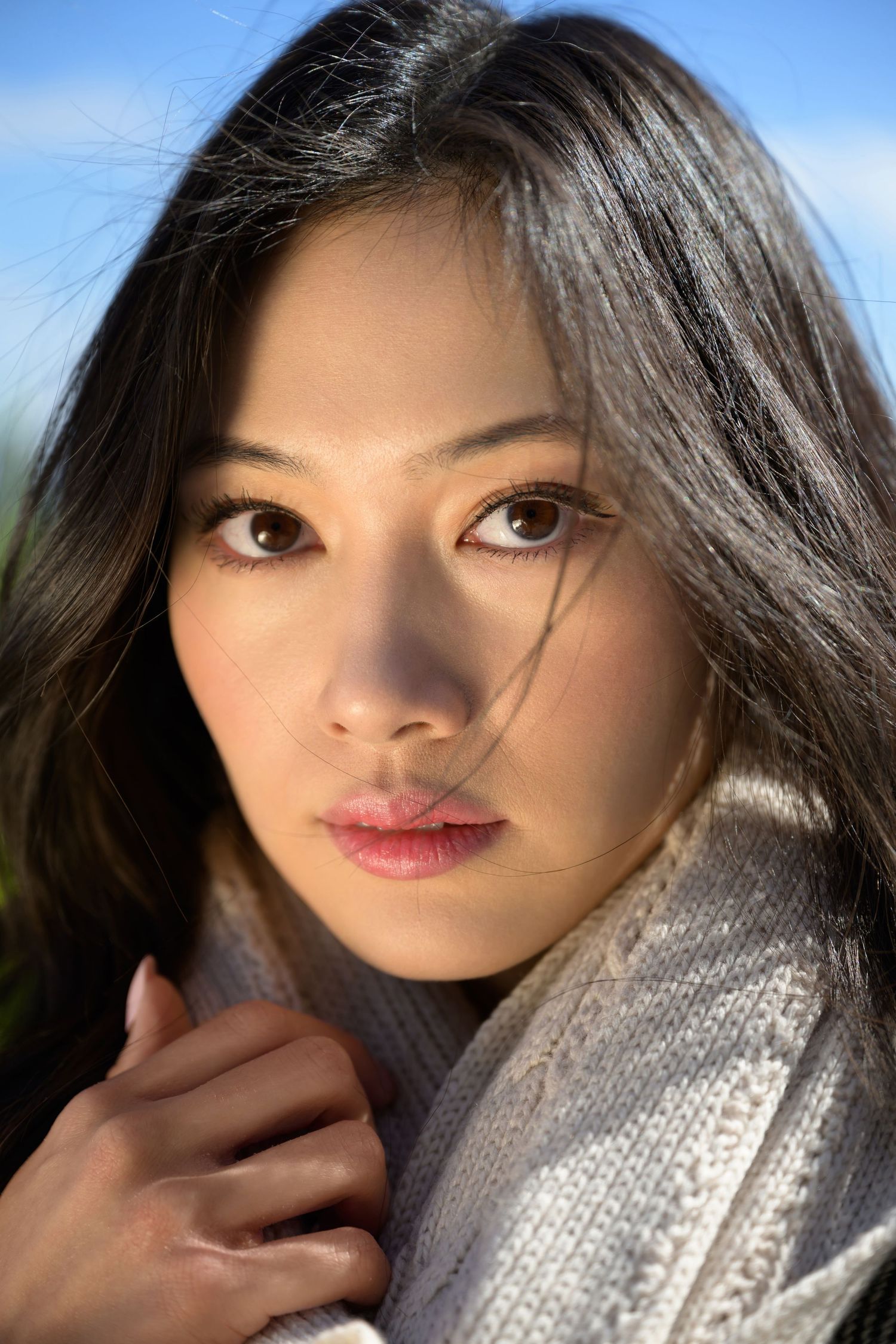 Close-up headshot of a model with no makeup and natural expression, taken outdoors in Zurich.