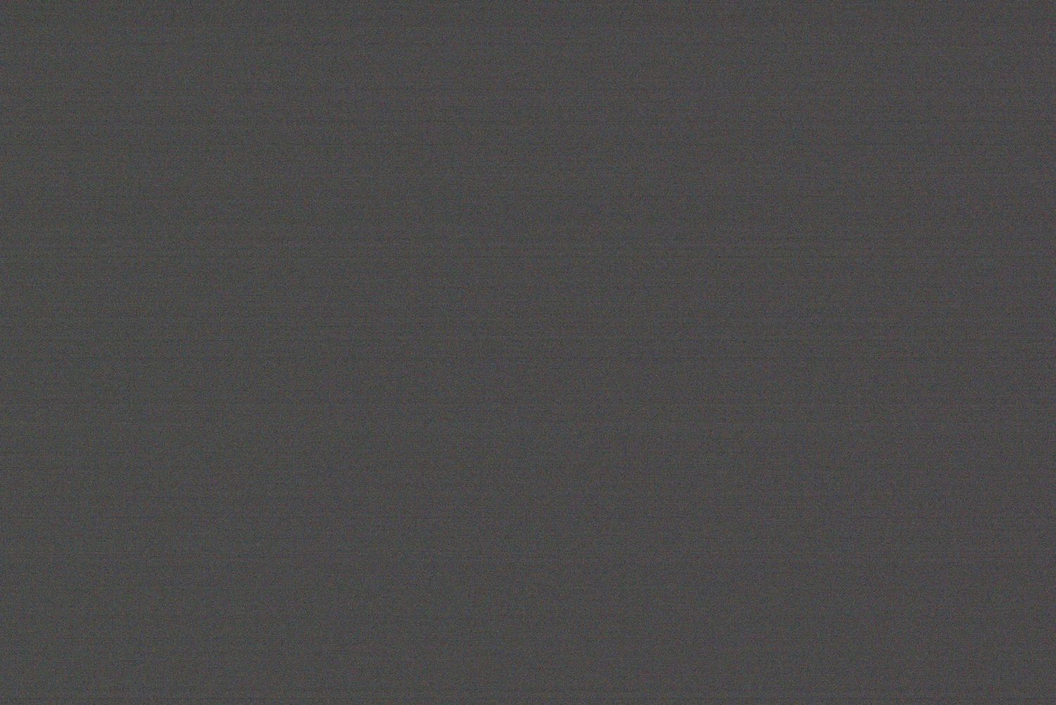 A textured dark gray background or surface with a subtle gradient effect.
