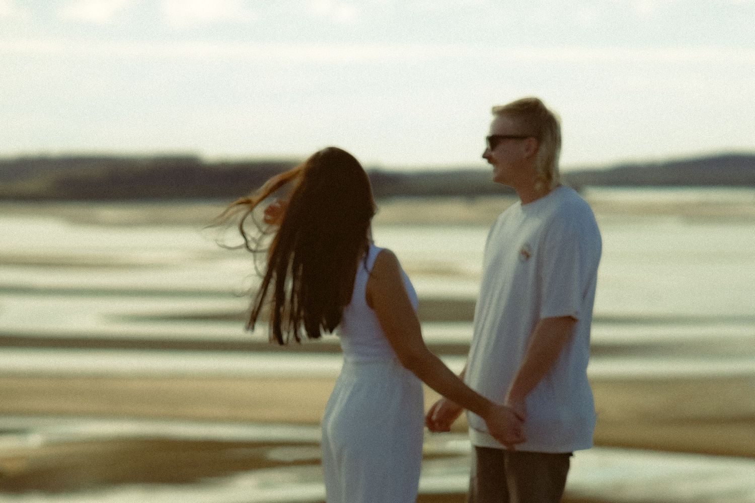 A couple sharing intimate moments on a scenic beach.