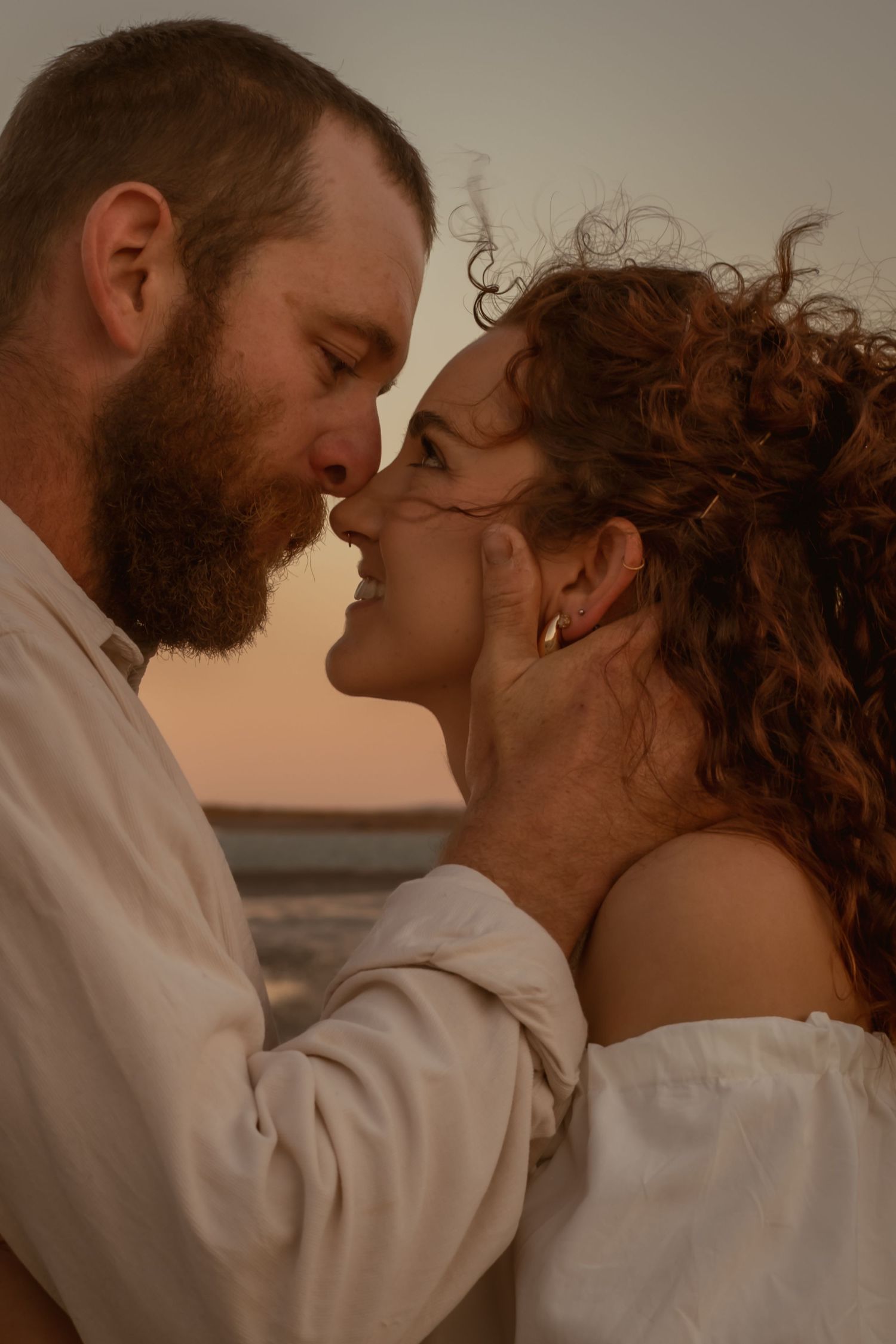 Intimate romantic moment captured between two people at golden hour.
