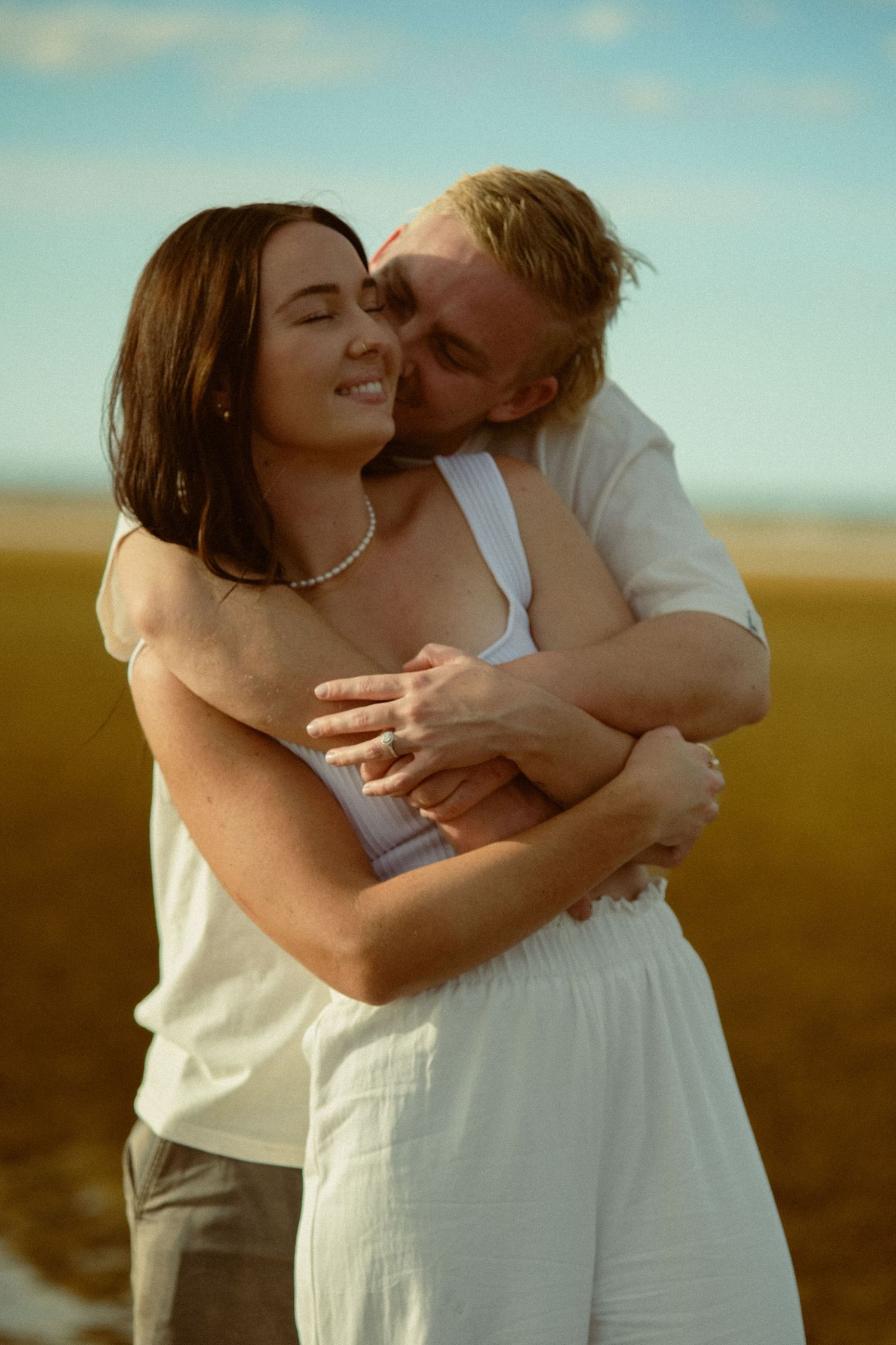 A romantic series of embraces captured on a sunny beach.