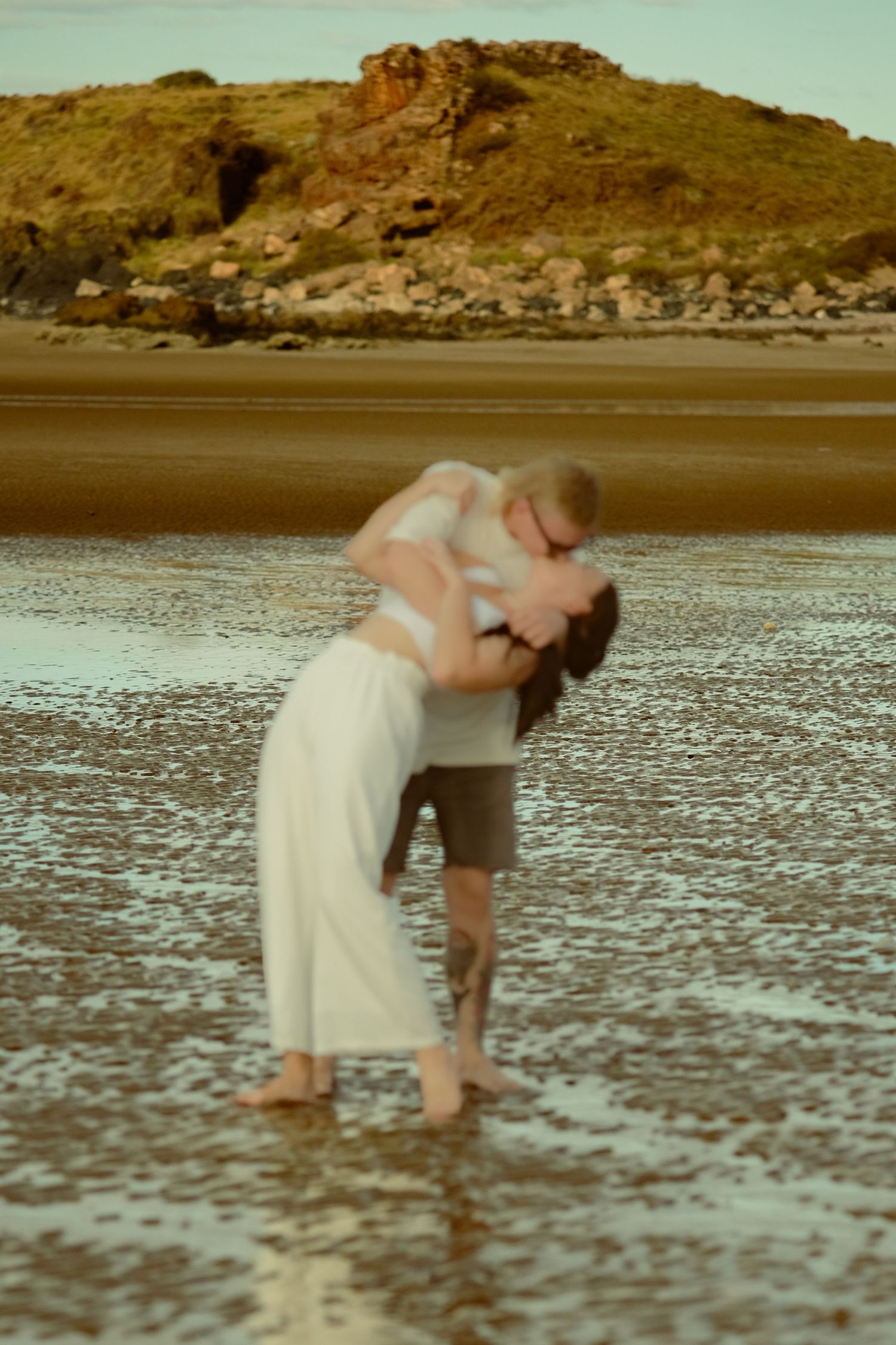 A series of photos showing someone bending down to explore the beach at low tide.