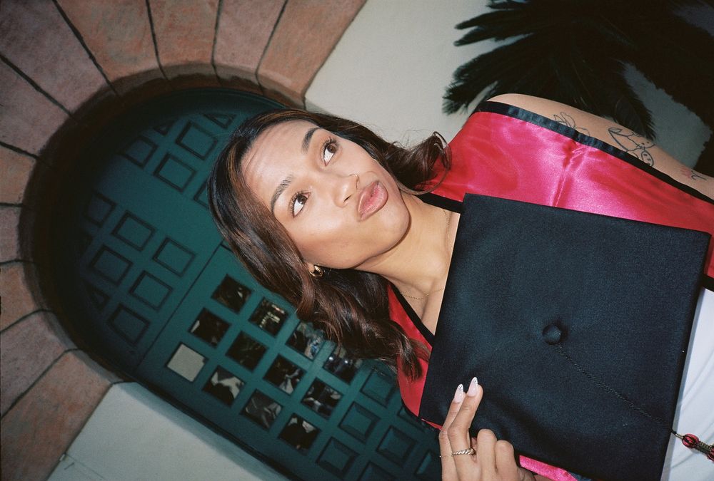 A young woman poses in front of a camera exposed by flash photography making her pop off the background