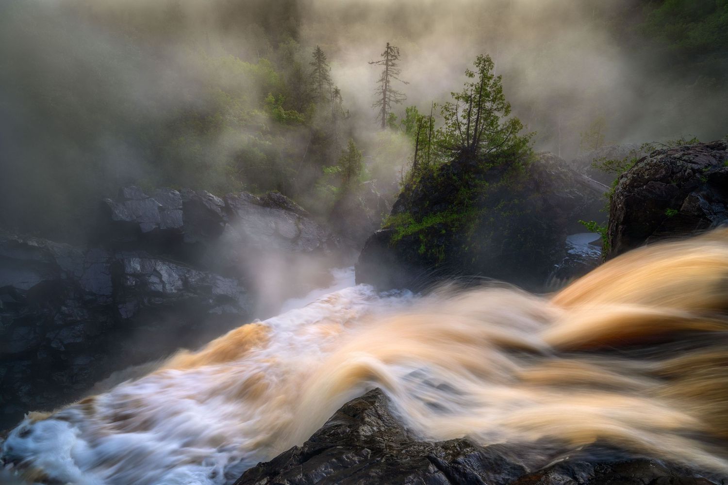 Misty mysterious waterfall cascades over rocks with golden sunlit water and ethereal fog in a moody forest scene.