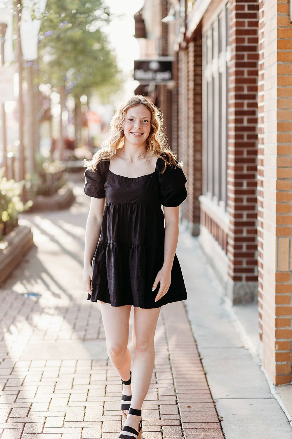A triptych of candid outdoor photos on a brick sidewalk featuring someone in a stylish black summer dress.