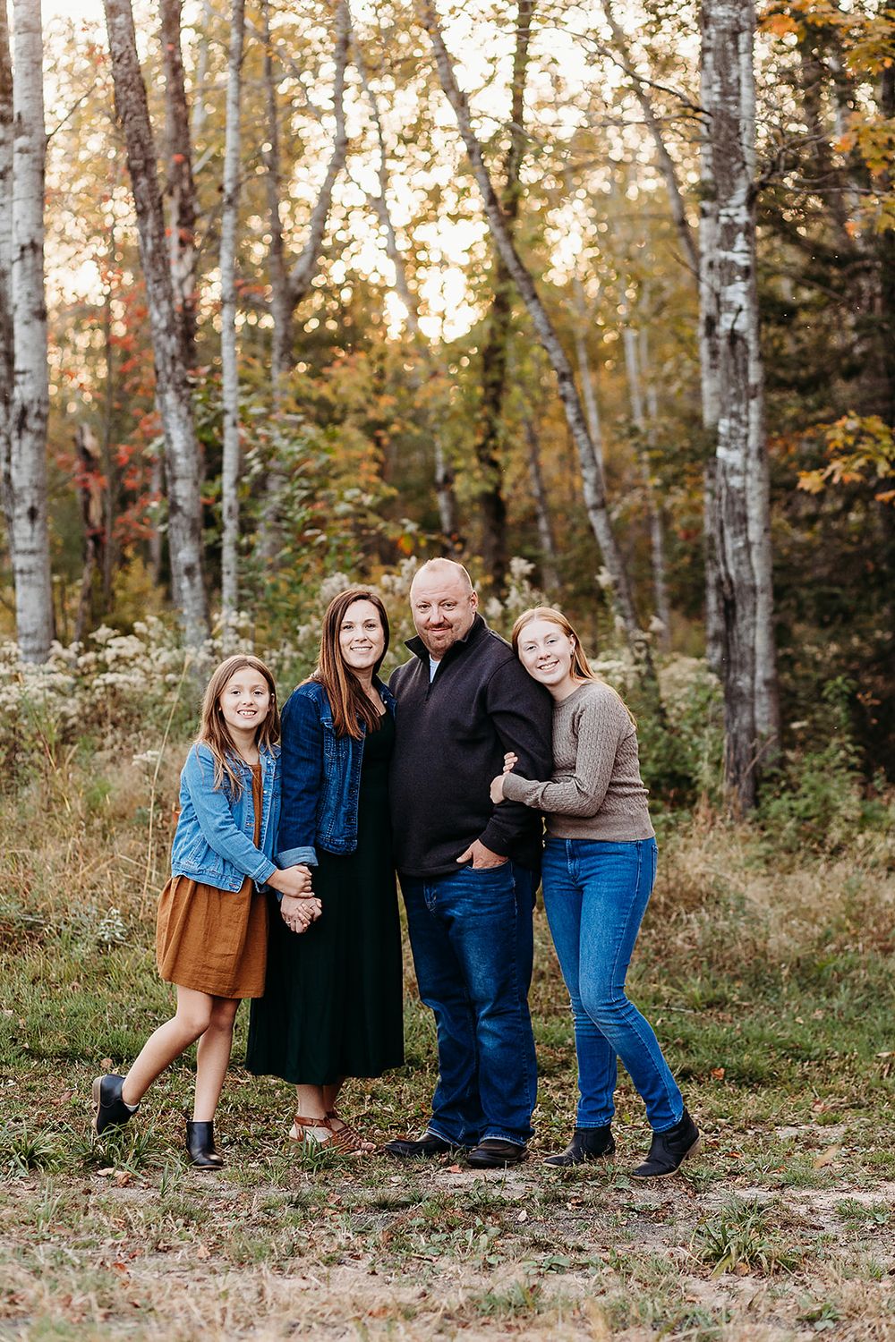 Three linked photos of a family posing in casual attire against an autumnal forest backdrop with birch trees.