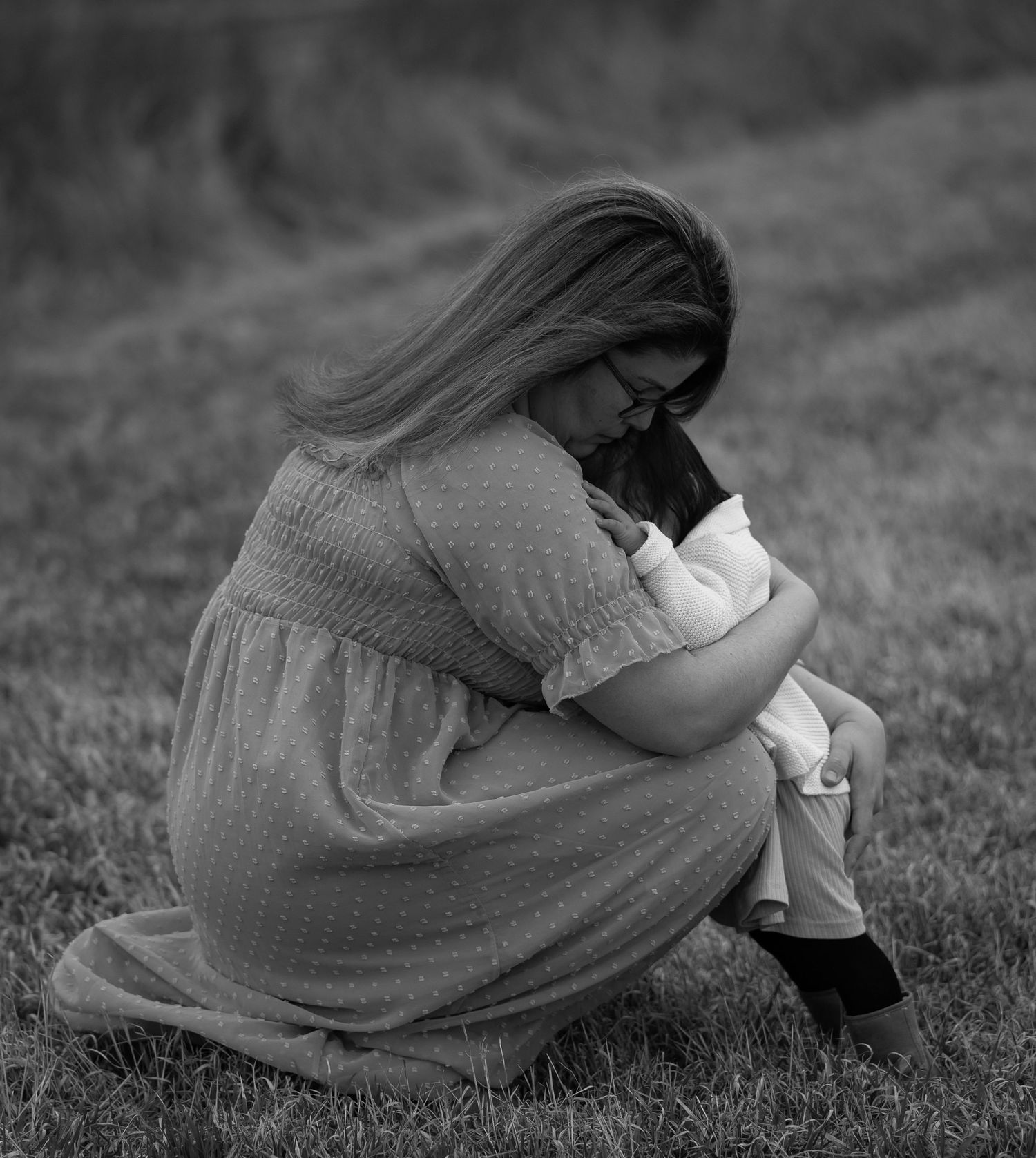 Black and white photos showing someone resting on grass in flowing fabric.