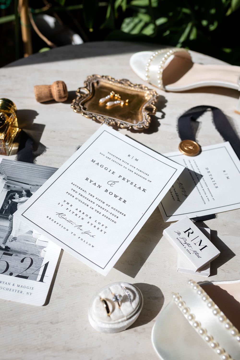 Elegant wedding invitation suite with vintage decor elements and bridal accessories in natural sunlight.