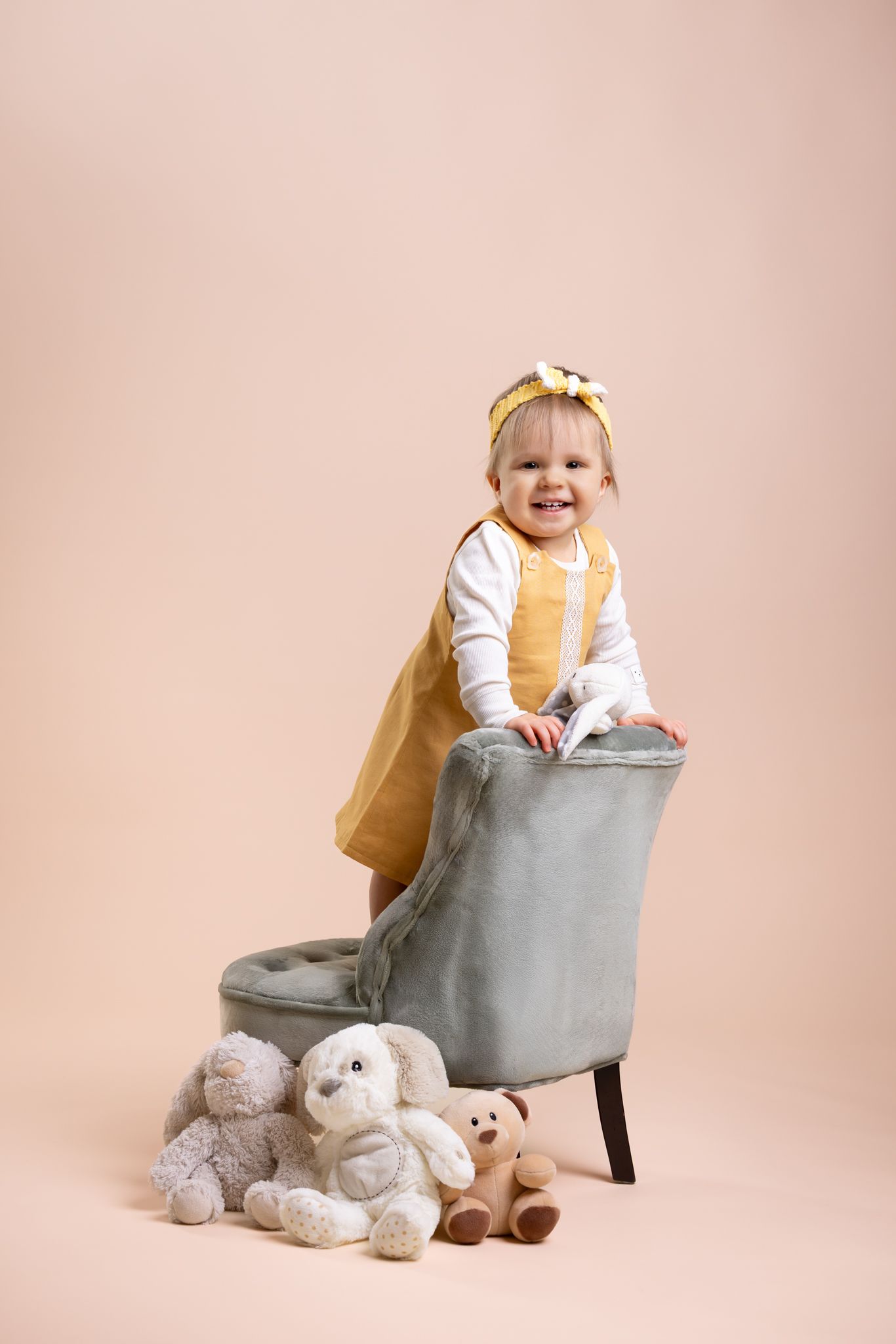 Three sequential photos show a child sitting in a gray chair with plush teddy bears on a pink background.