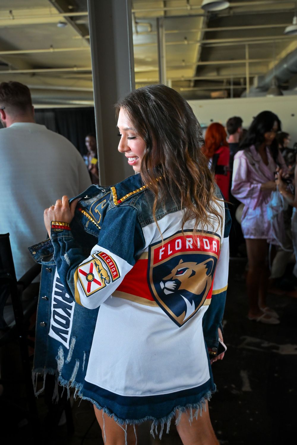 Person wearing a Florida Panthers hockey jersey and denim jacket poses at an indoor event.
