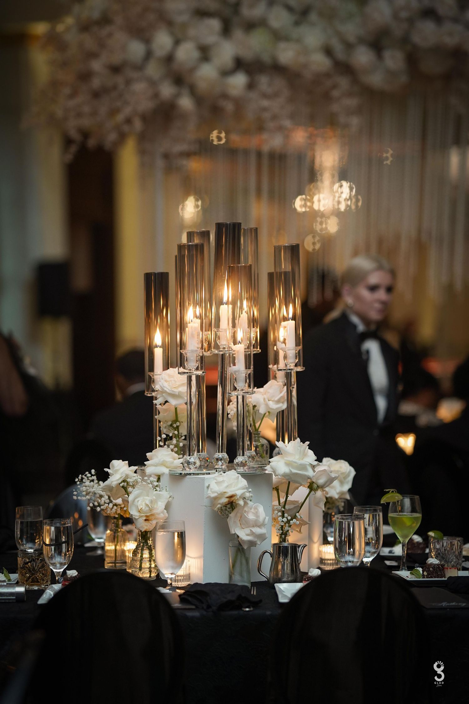 Elegant crystal chandelier with multiple tiers hangs from an ornate coffered ceiling in a luxurious ballroom.
