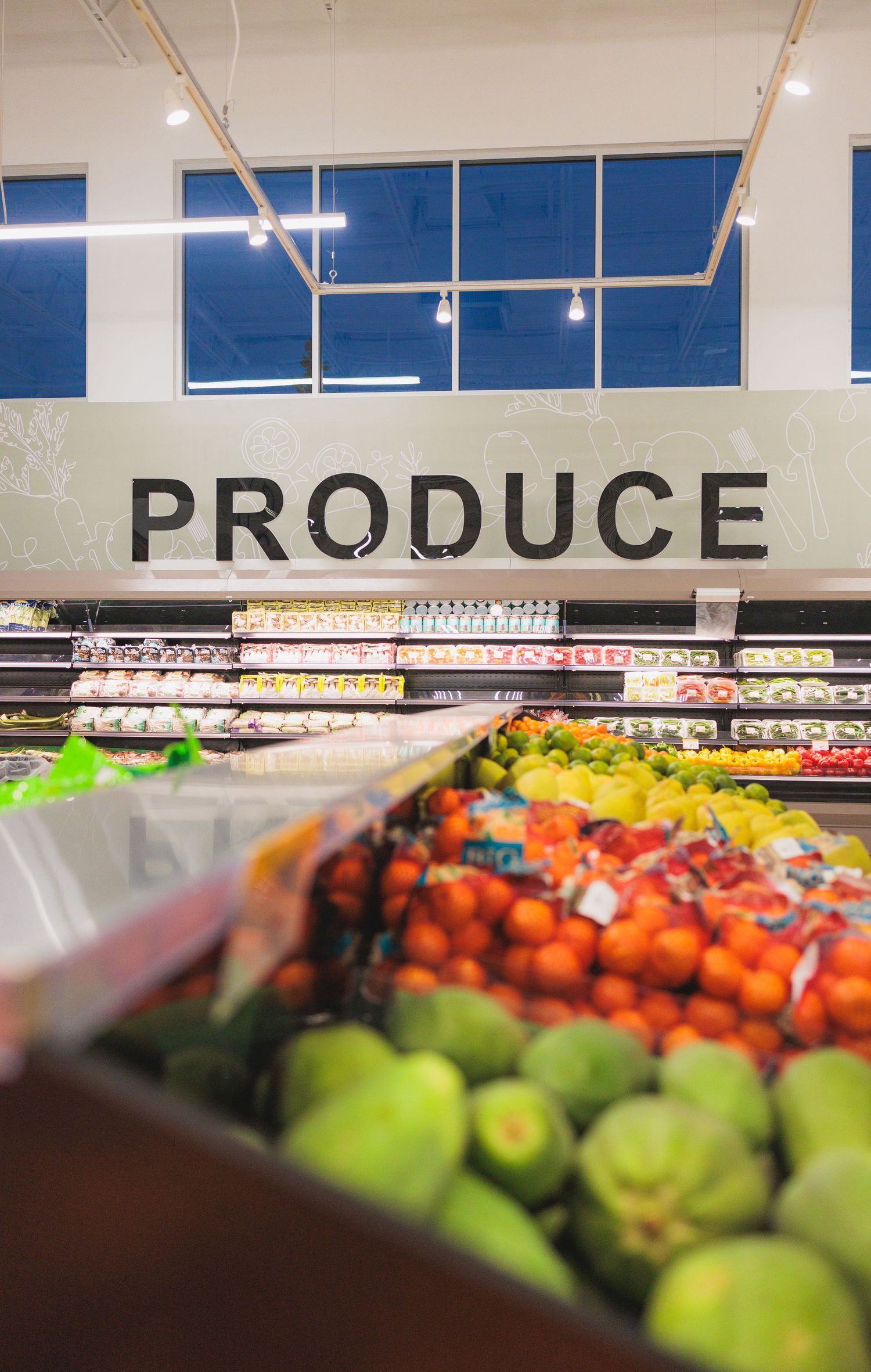 Fresh produce section of a grocery store with bright lighting and organized displays.