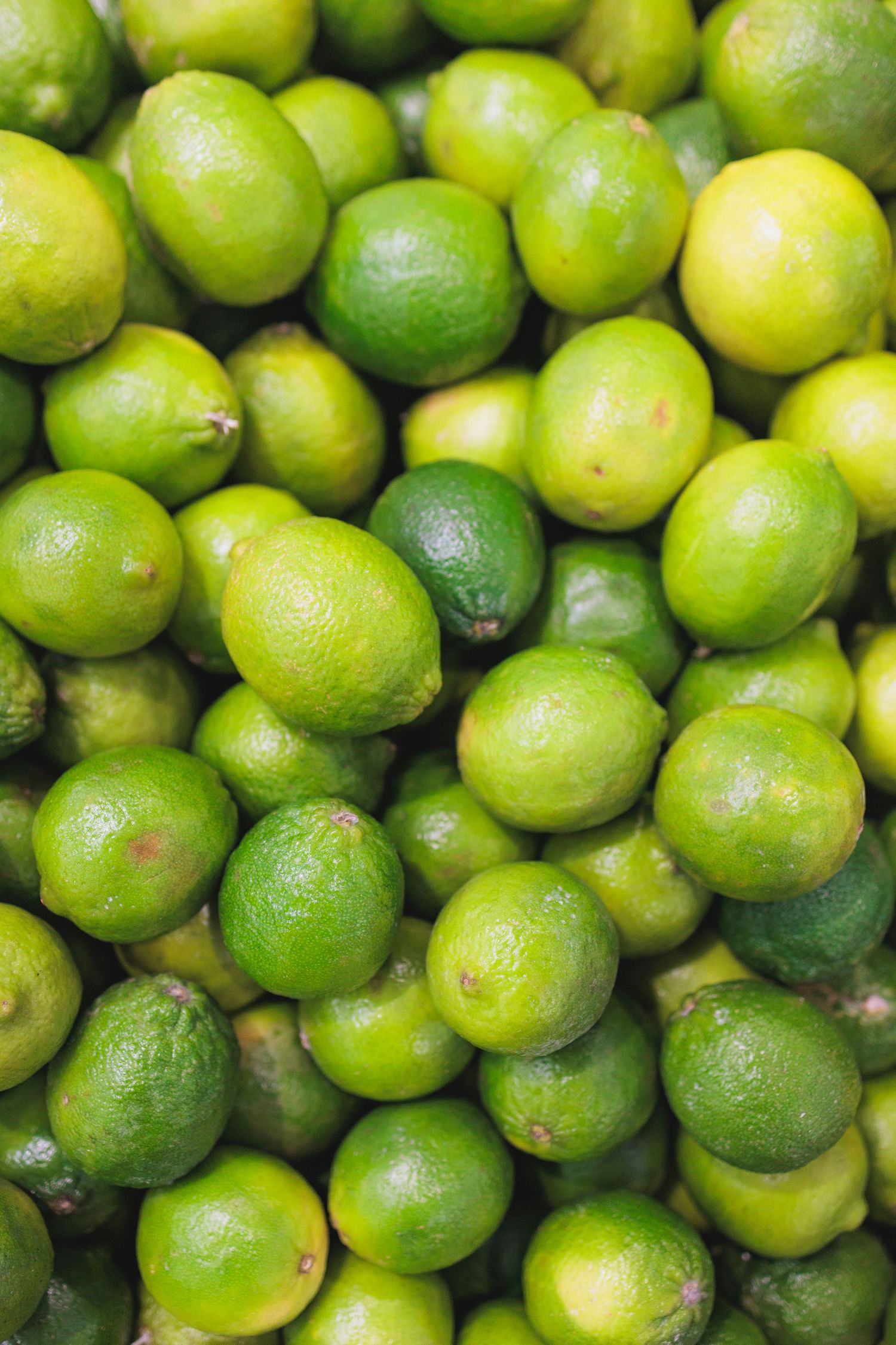 Fresh lime citrus fruits arranged in a vibrant green display.