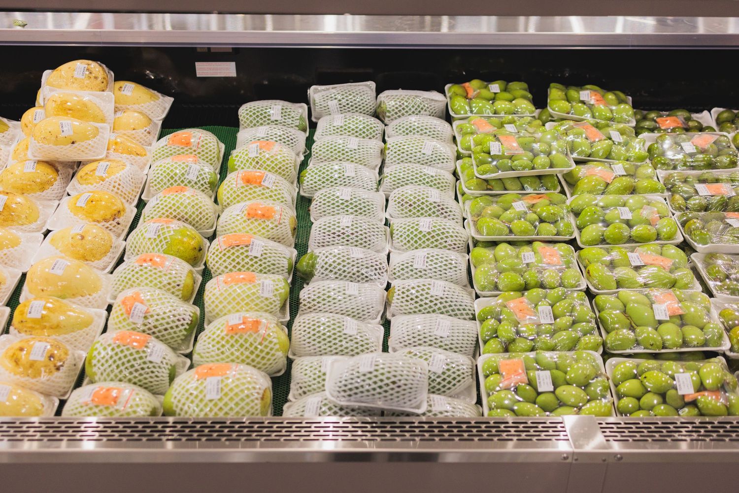 Rows of packaged sushi rolls displayed in a refrigerated grocery store case.