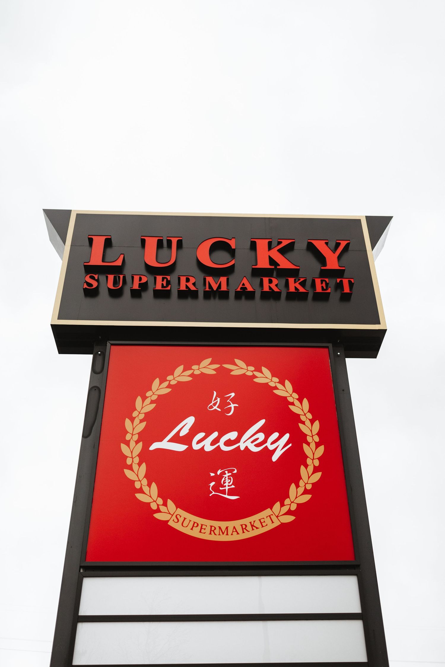 Red illuminated Lucky Supermarket sign mounted on a storefront.