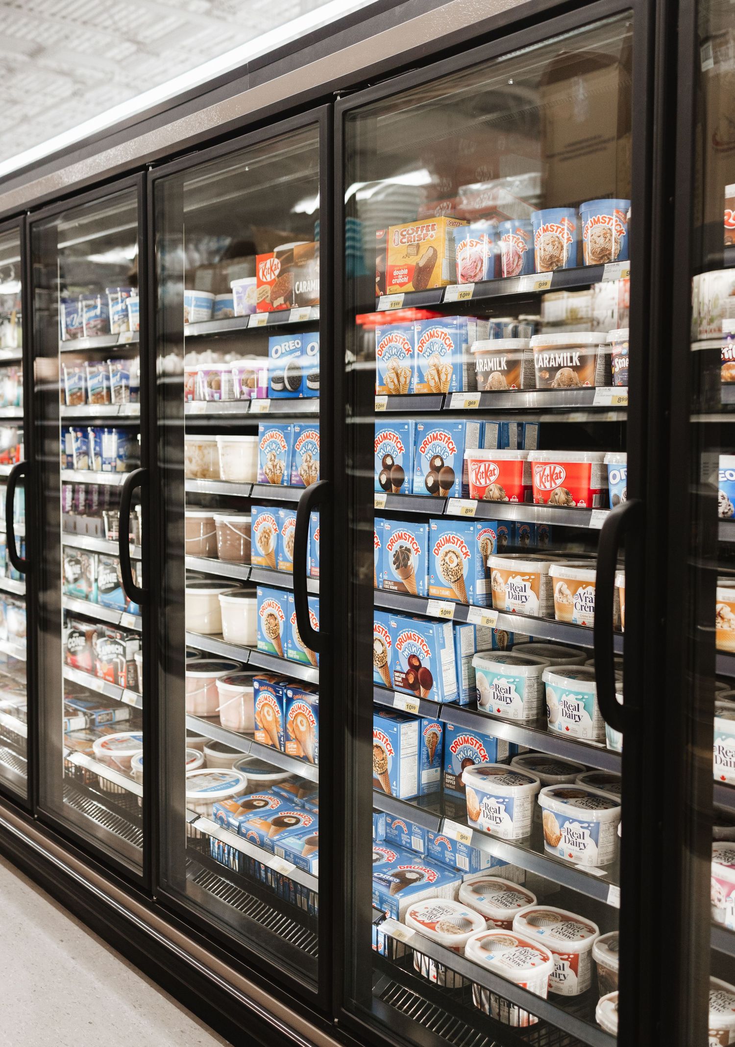 Long row of refrigerated display cases filled with frozen foods in a grocery store.