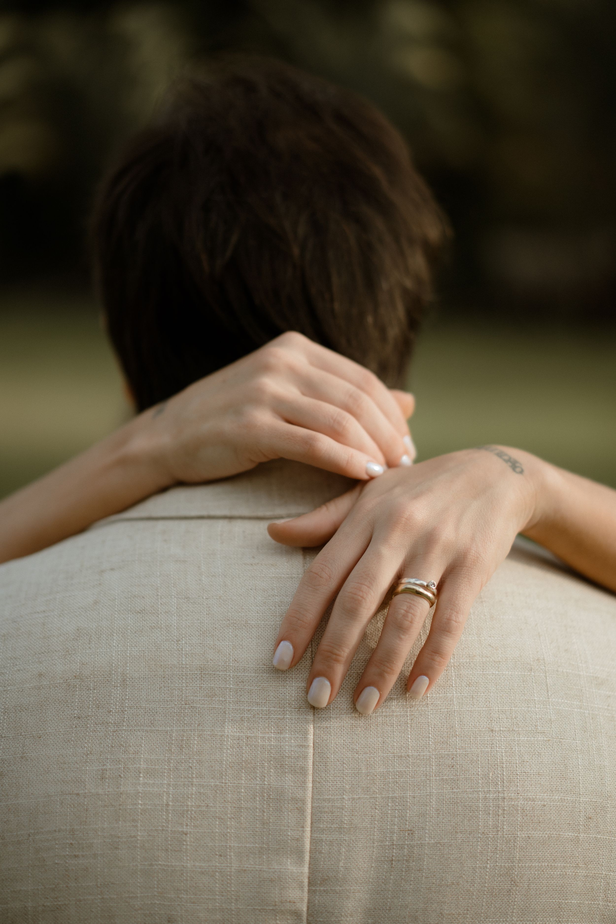 Close up of hands with wedding ring embracing in an intimate moment.