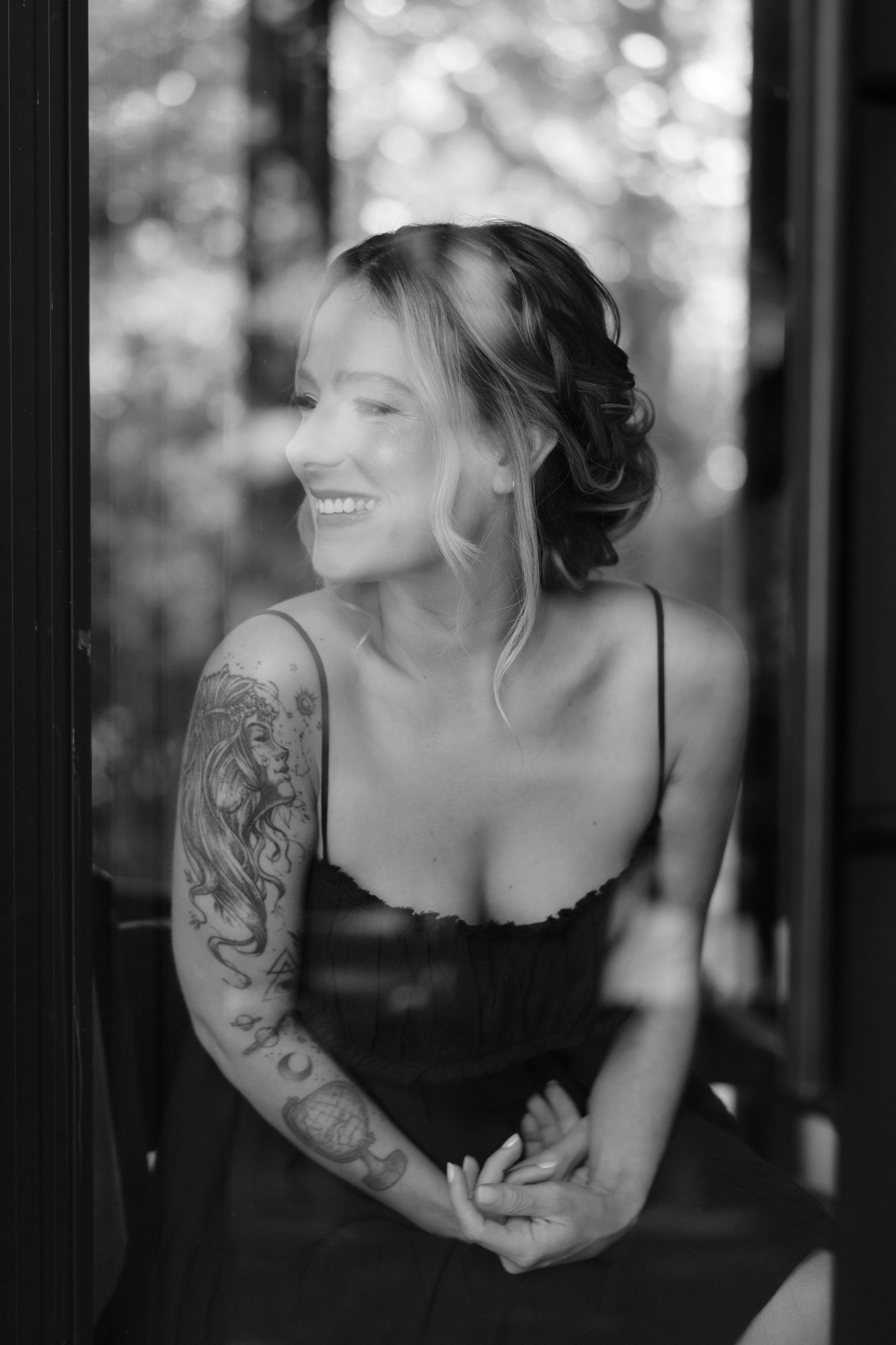 Black and white portrait showcasing delicate lace details and artistic tattoo work.