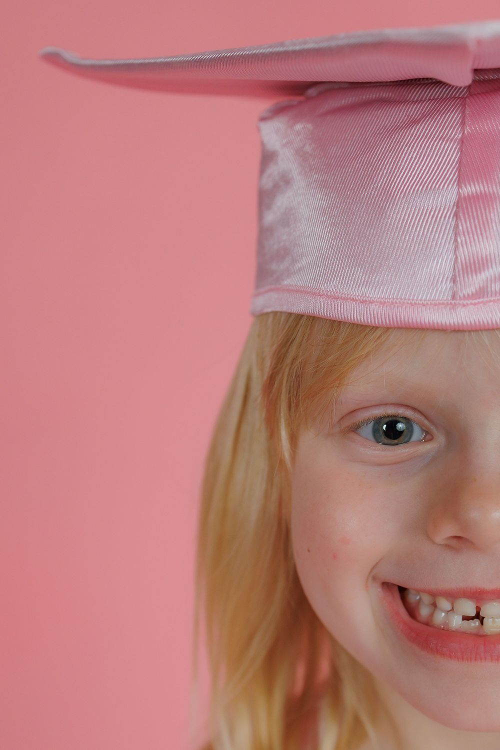 Cropped image series showing a progressive close up of a child's smiling face against a pink background.