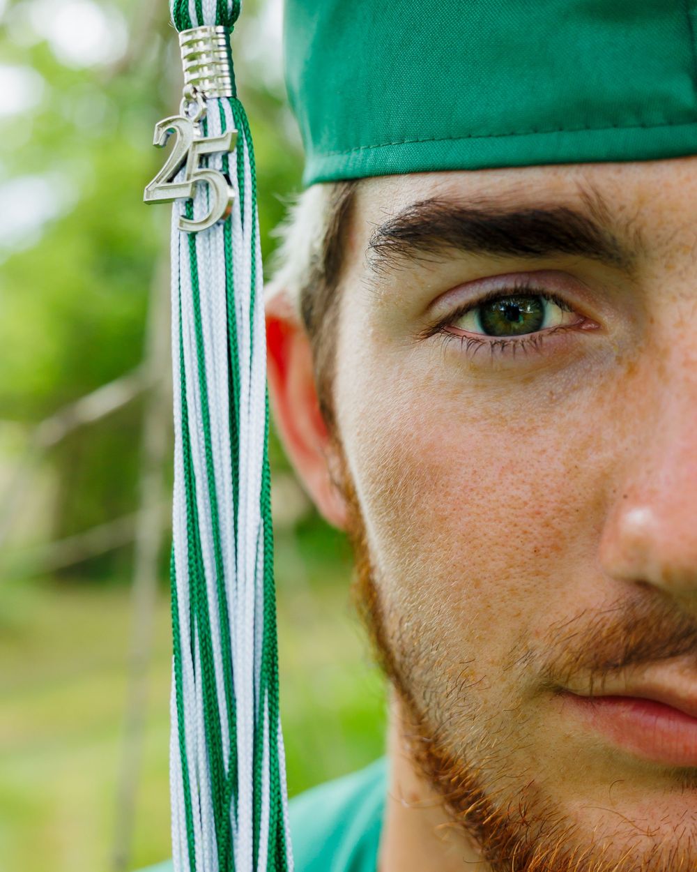 Closeup partial view through green foliage with emerald colored glass or plastic bottles visible in the background.