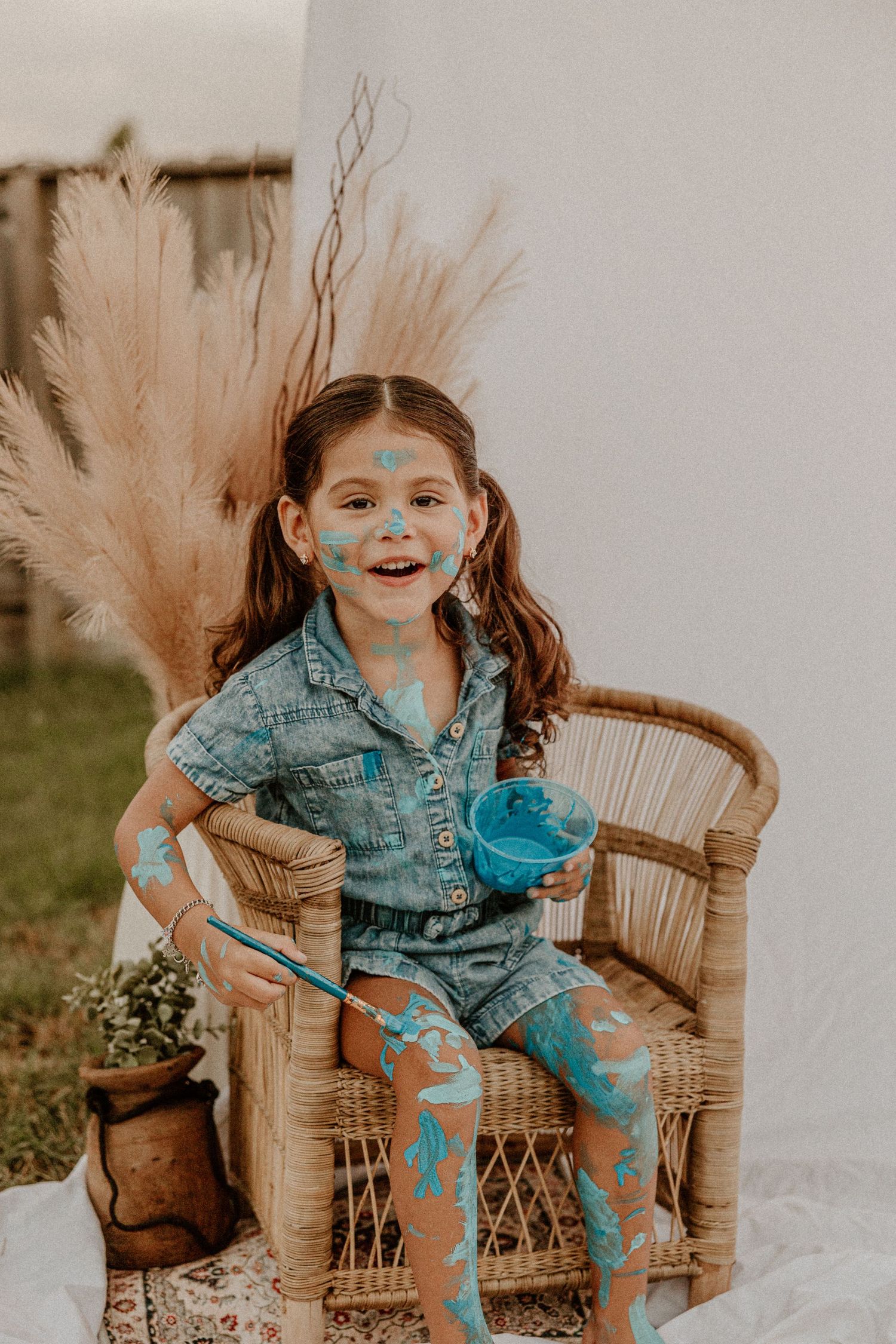 A playful scene with painted blue patterns against neutral pampas grass decor.