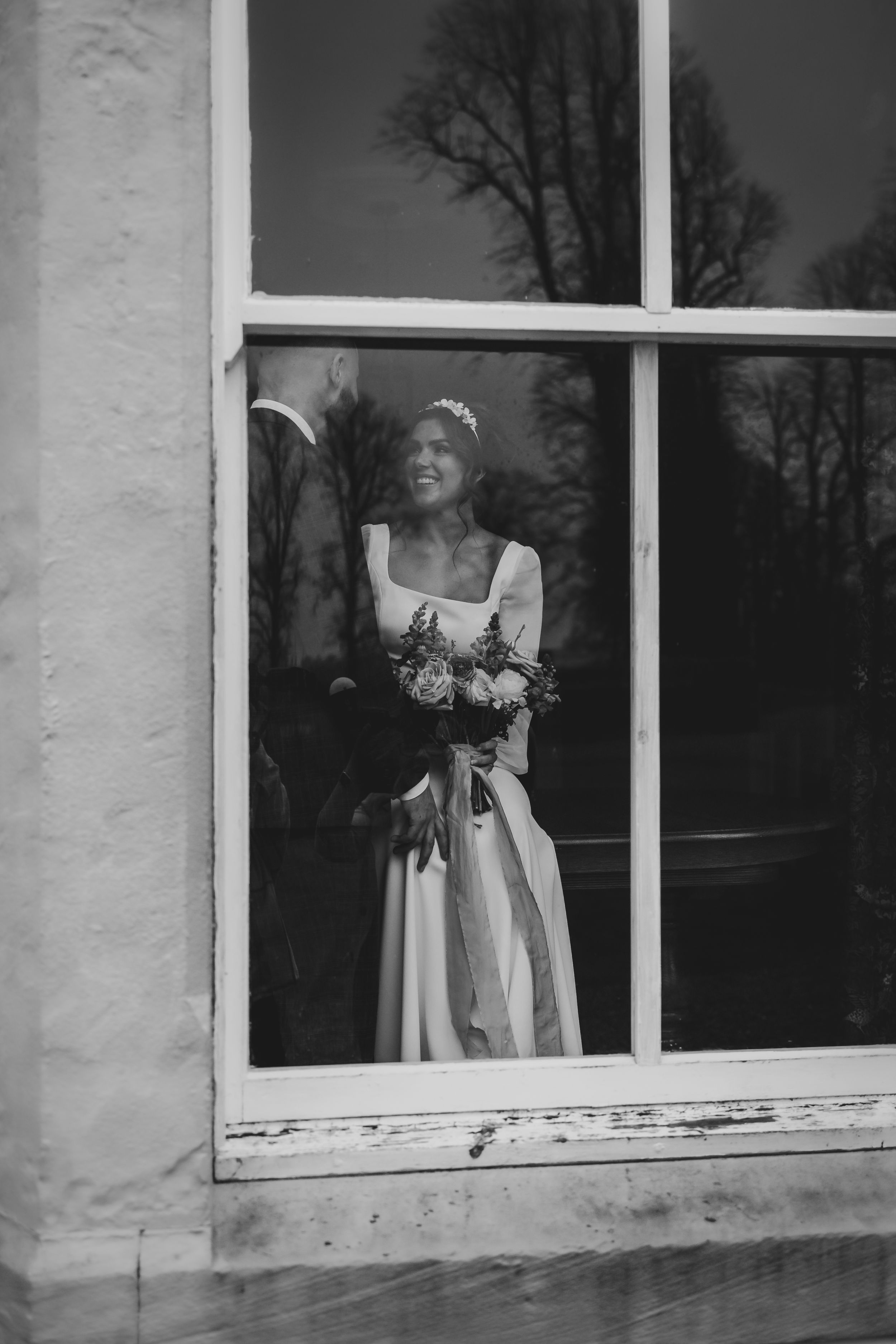 non-traditional wedding photographer in the Lake District - bride and groom In the  windows
