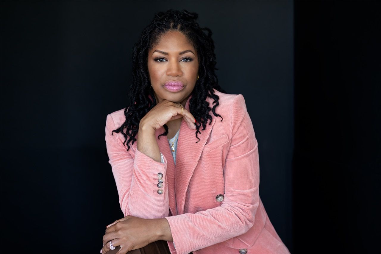 Portrait of African American Woman Entrepreneur against a black background.