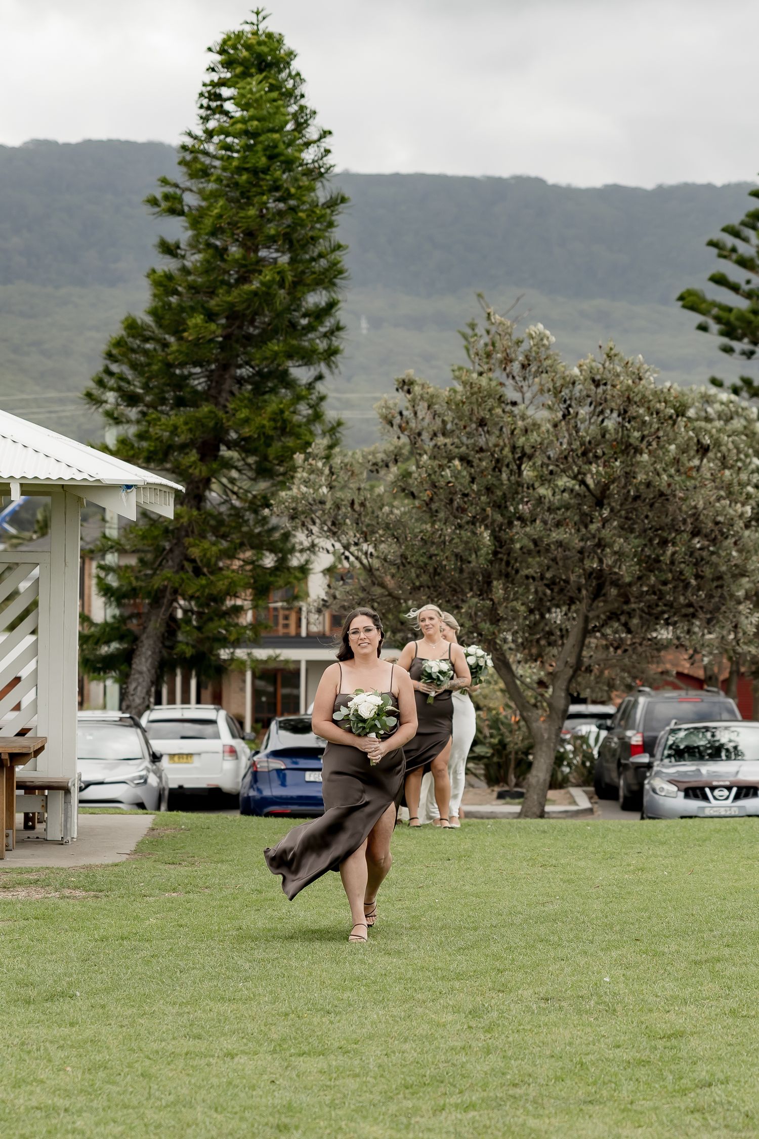 Wedding guests playing outdoor lawn games at a beachside venue with trees in the background.