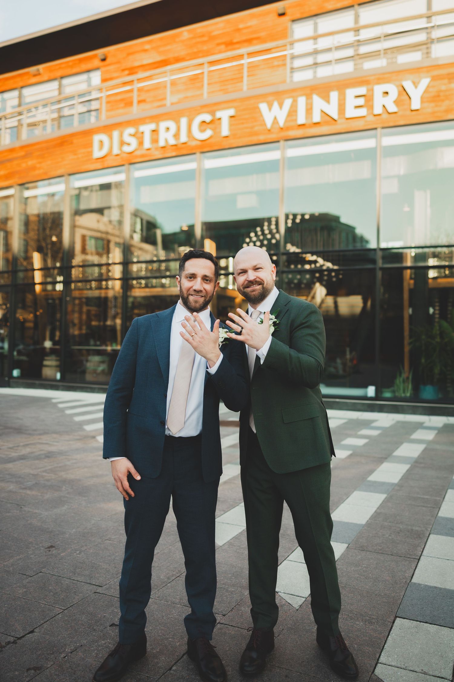 Grooms, newly married, standing in front of the District Winery DC wedding venue