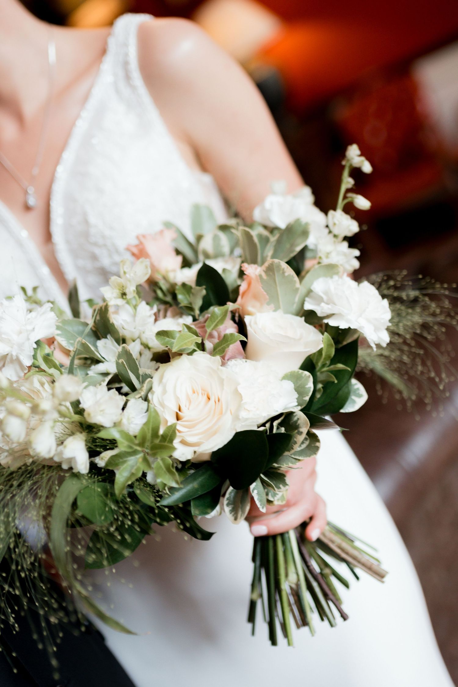 A delicate bridal bouquet featuring white and blush flowers with green foliage shown from multiple angles.