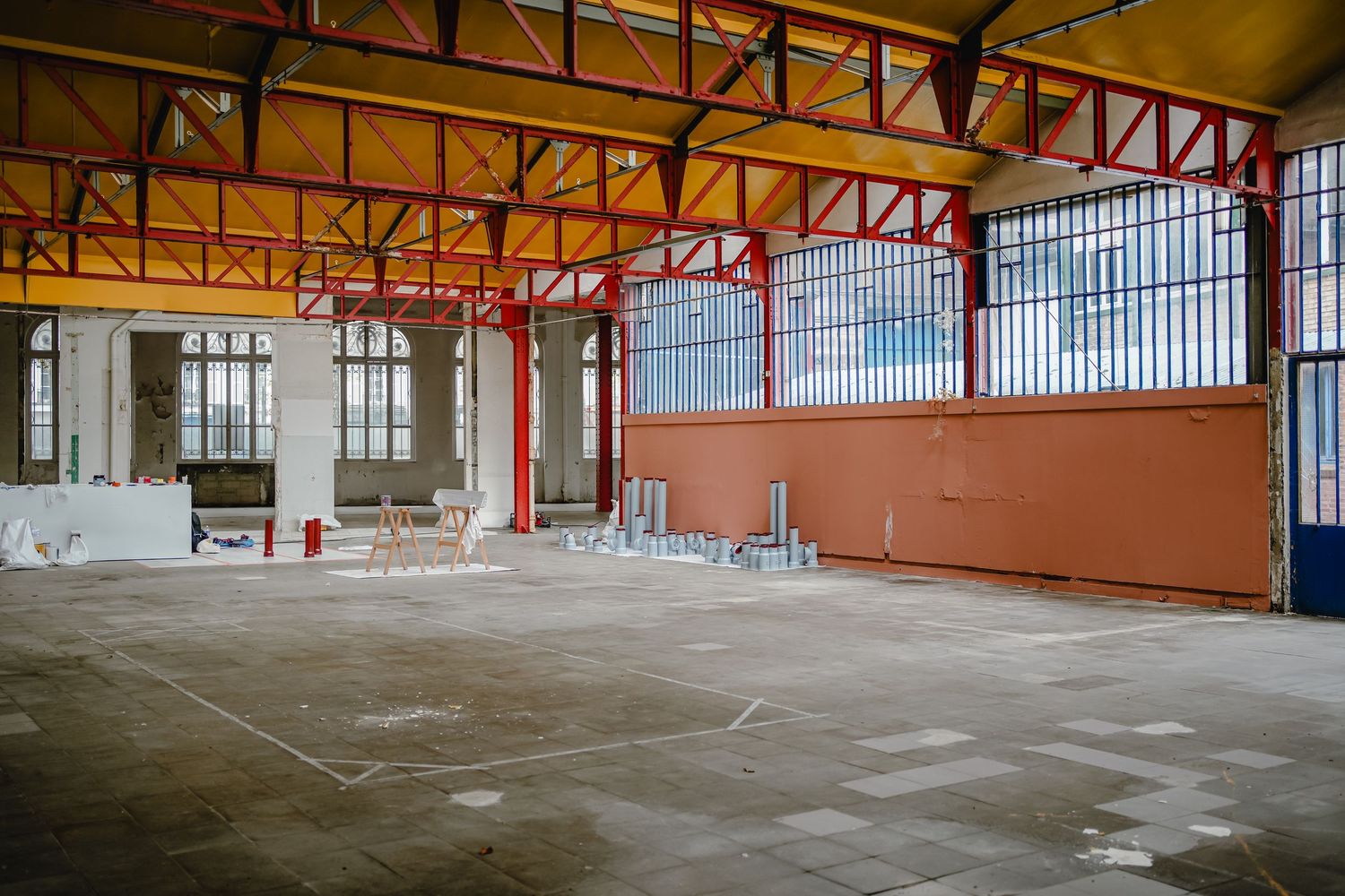 Large empty industrial warehouse interior with exposed steel beams and concrete floor showing multiple angles of the space.