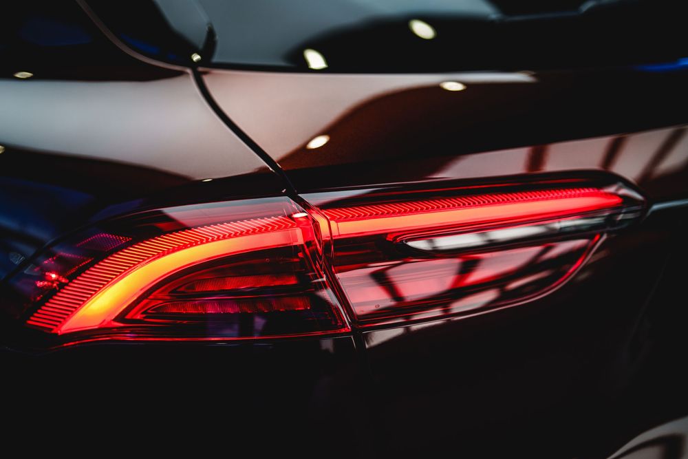 Modern car taillights glowing red in dark lighting conditions create a sleek and futuristic automotive design element.