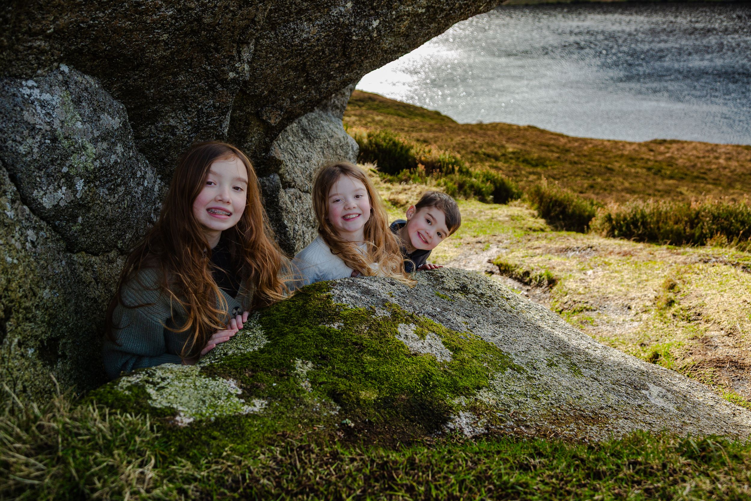 children photographed while enjoying the views of Lough Bray with moss-covered rocks
