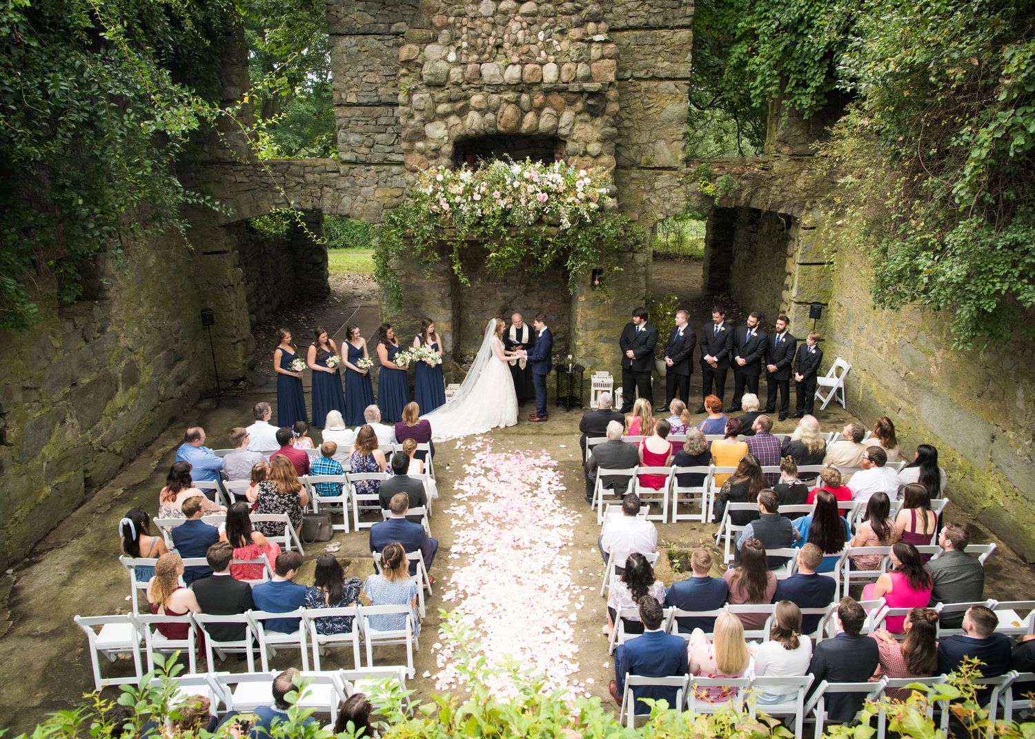 Rustic barn wedding reception venue with wooden beams, chandeliers and round tables set for an elegant celebration.