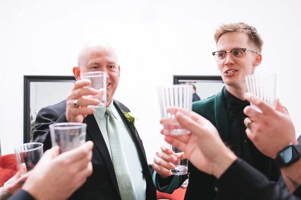 People raise glasses in a celebratory toast at what appears to be a formal gathering or event.