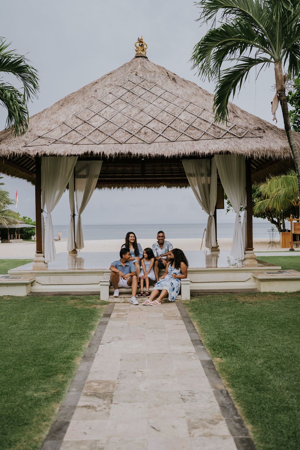 Family photoshoot experience at Nusa Dua Beach Hotel Bali with seaside backdrop.