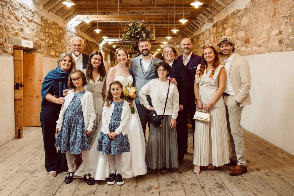 A series of wedding party photos in a rustic stone venue showing guests in formal attire and denim jackets.