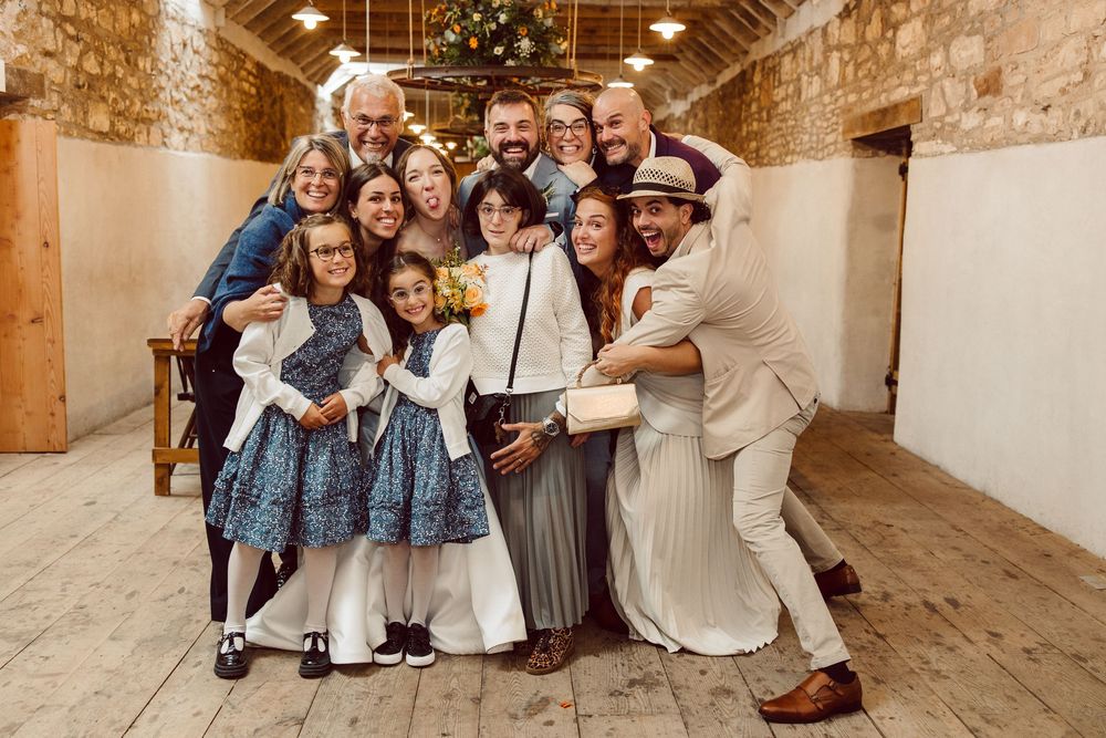 A group poses together in a rustic stone building with exposed wooden beams and natural lighting.