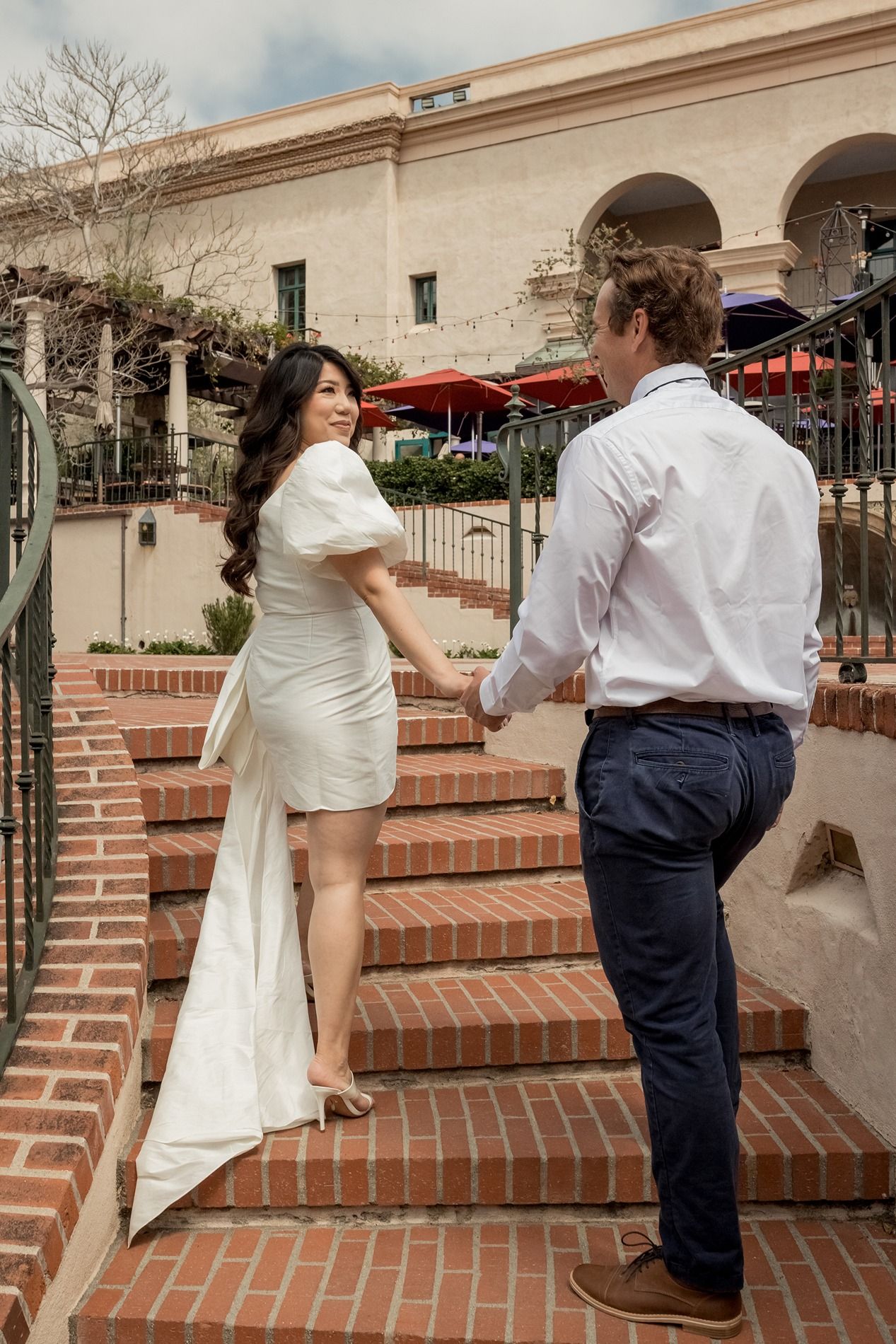 A couple walking on brick steps showing their playful movement at Balboa Park in San Diego.