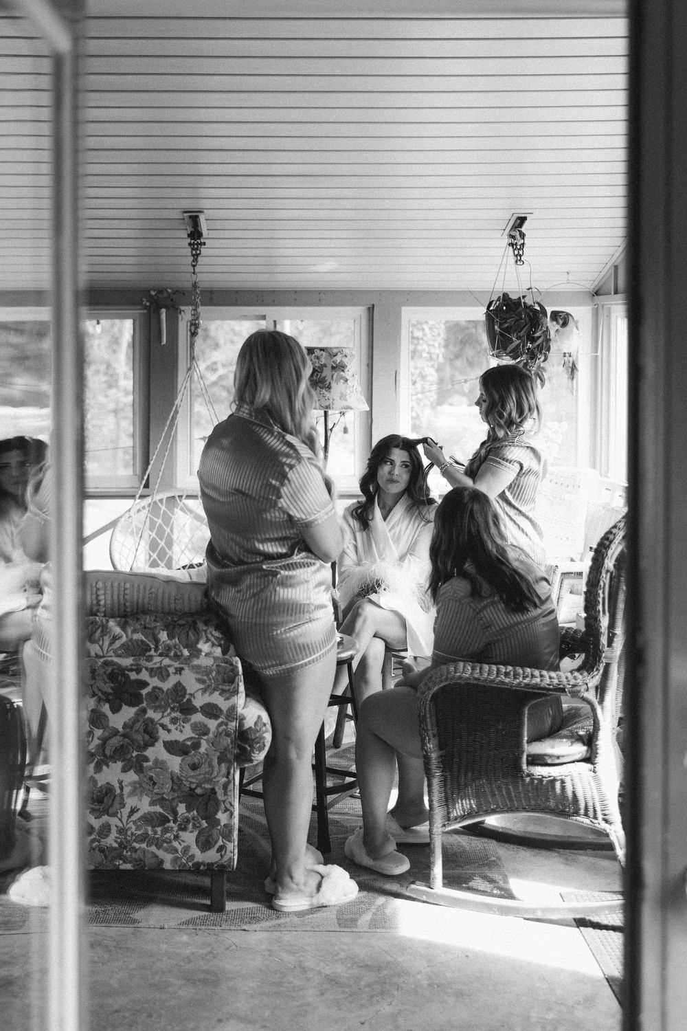 A panoramic black and white image of people sitting in a sunlit room with windows.