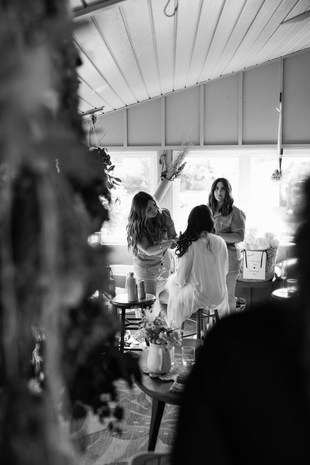 Black and white candid shots of guests mingling at an indoor party under white ceiling panels.