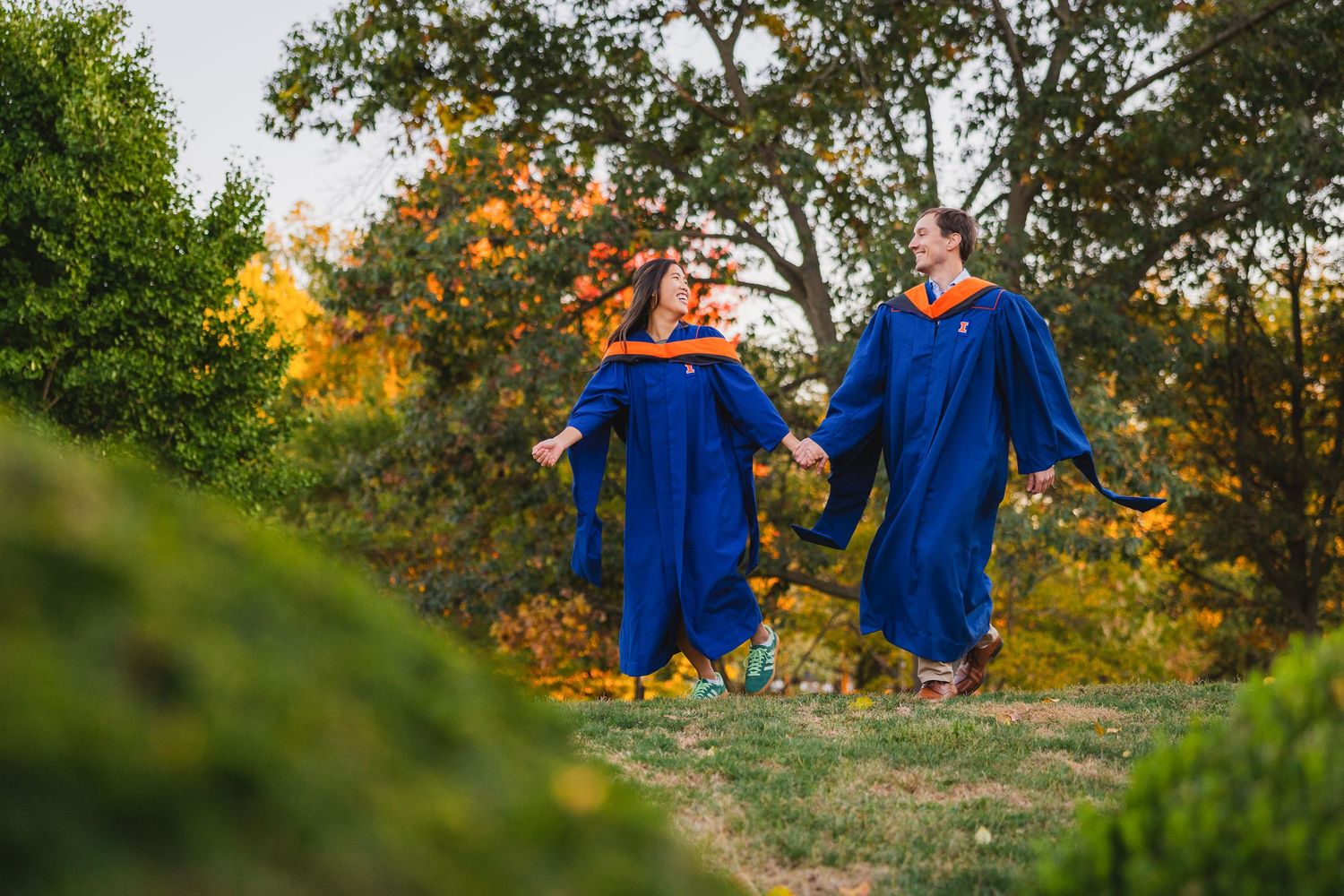 UIUC graduating couple running together surrounded by greenery at Japan House