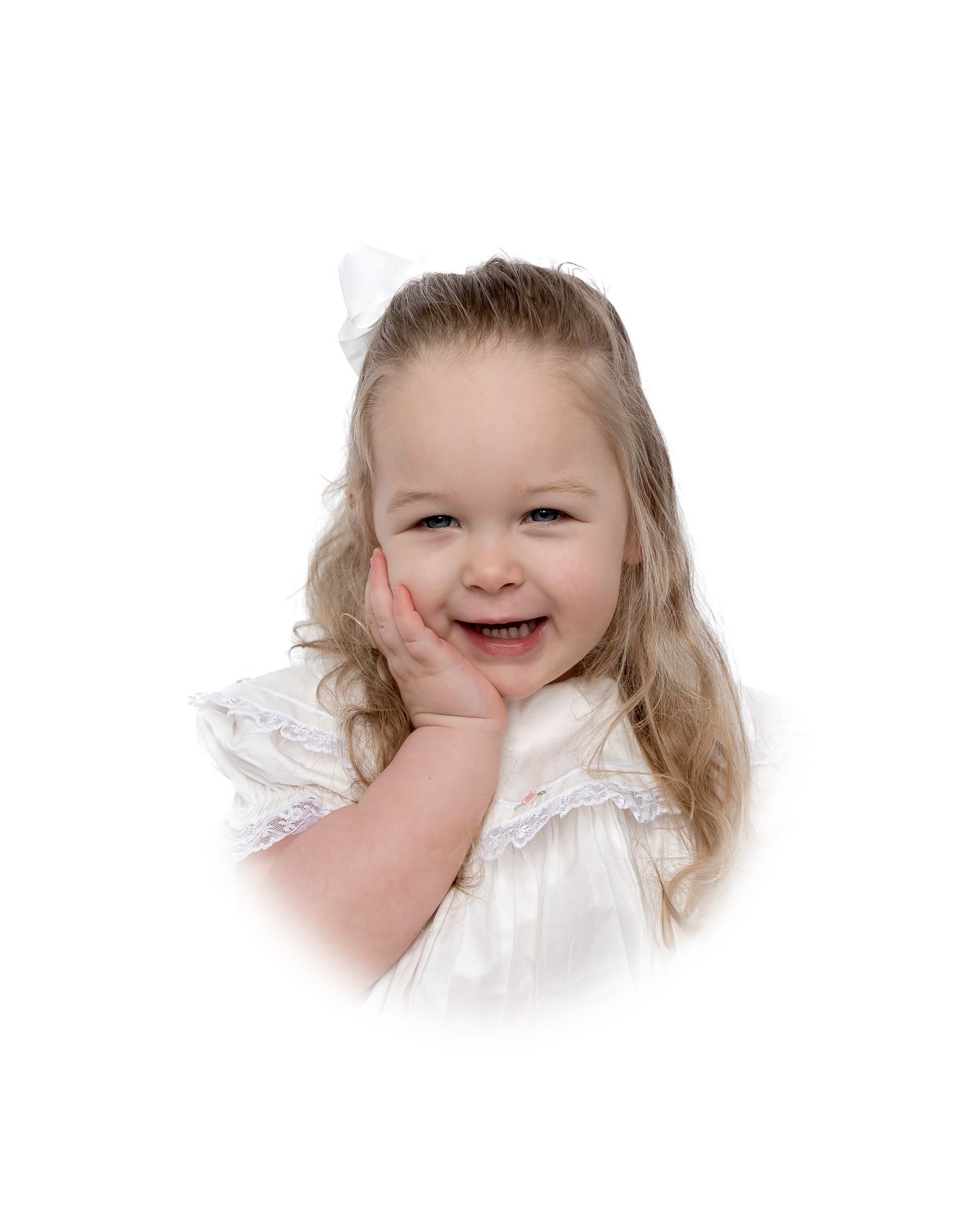 A happy child with blonde hair wearing a white lace dress smiles brightly against a white background.