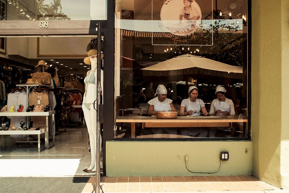 View through window of restaurant kitchen staff working at counter.