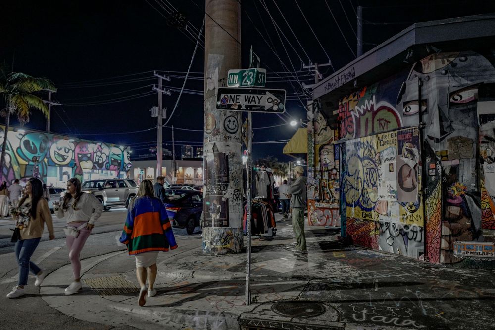 Graffiti covered walls and street signs in urban nighttime scene.